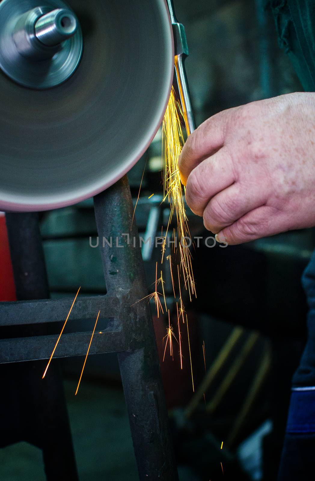 Industrial grinder showers sparks while working with metal.