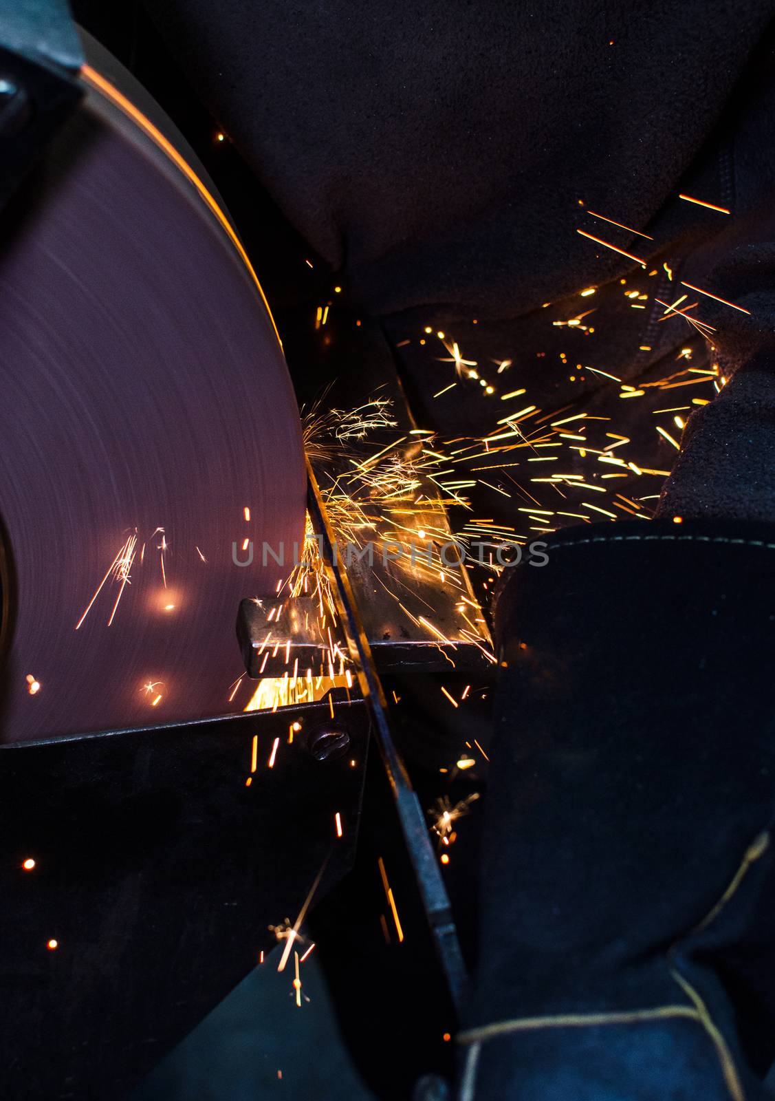 Industrial grinder showers sparks while working with metal.