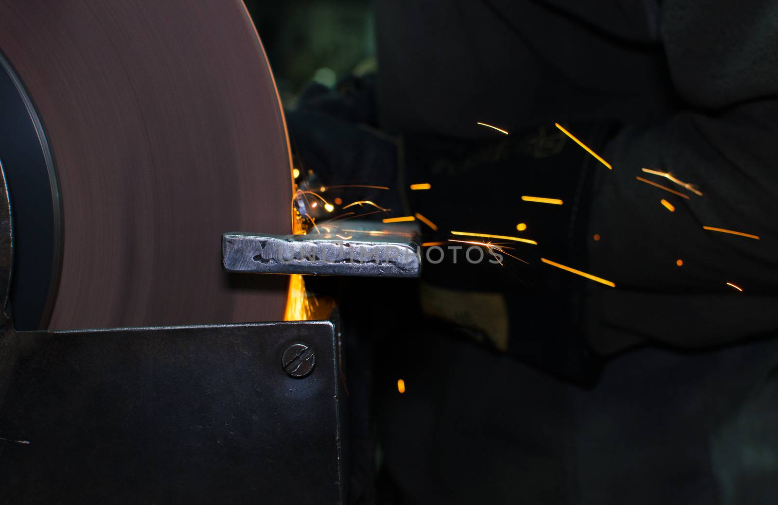 Industrial grinder showers sparks while working with metal.