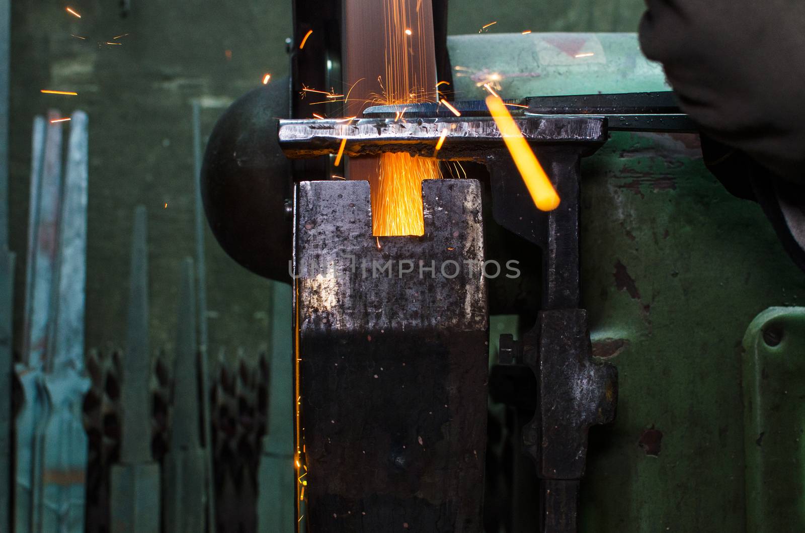 Industrial grinder showers sparks while working with metal.