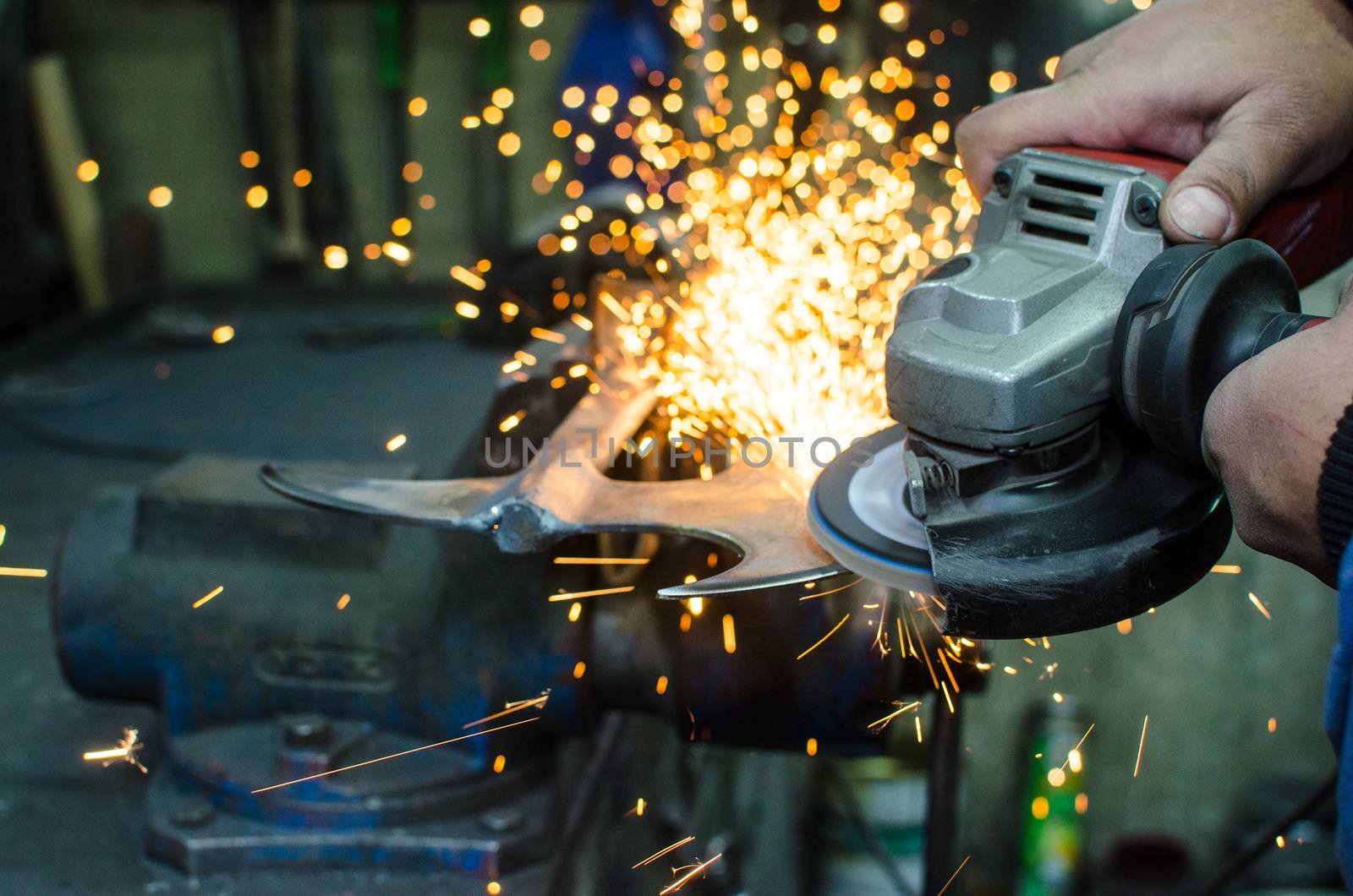 Industrial grinder showers sparks while working with metal.