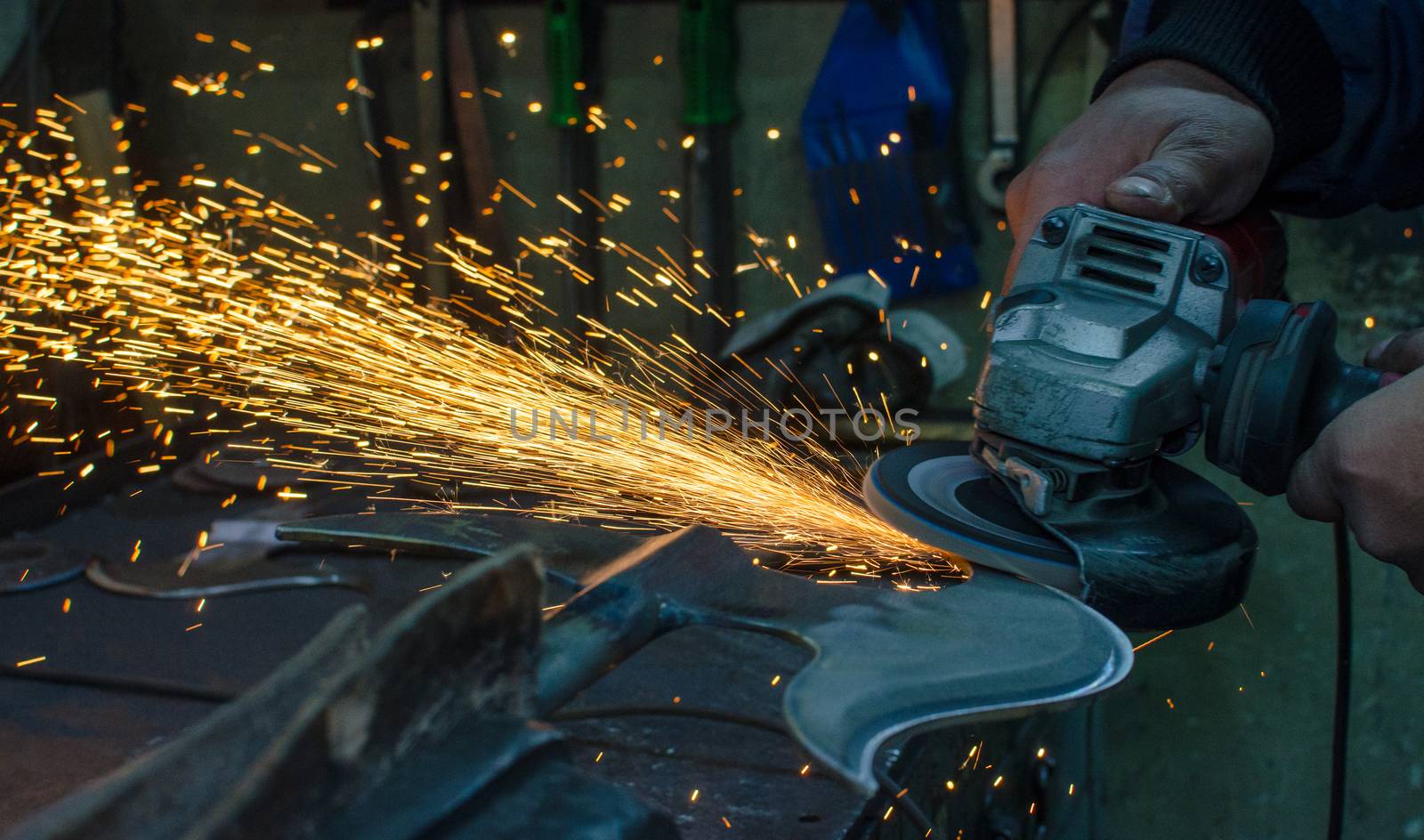 Industrial grinder showers sparks while working with metal.