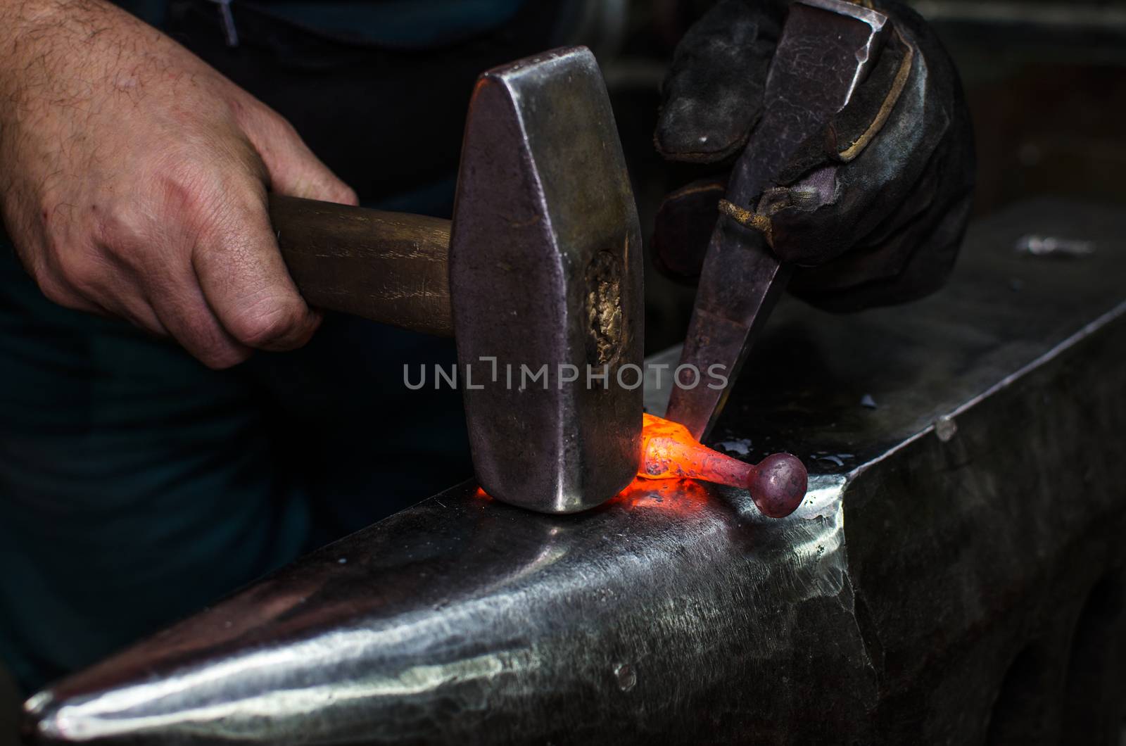 Blacksmith at work, hit with a hammer by a hot metal on the anvil.