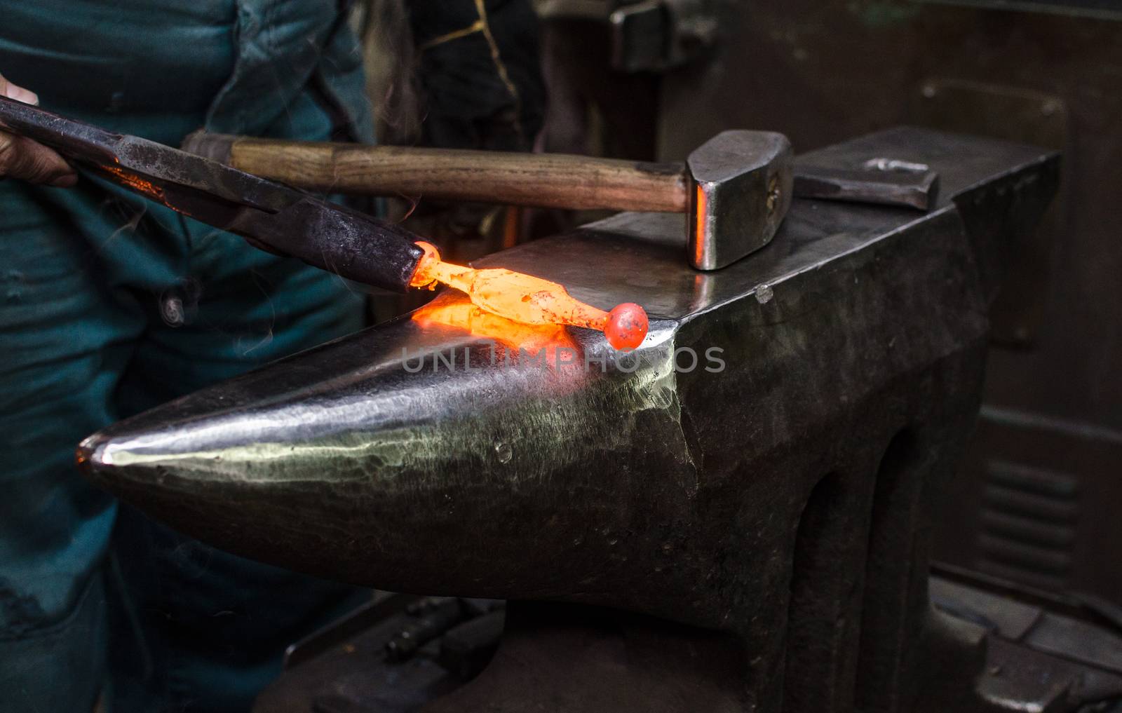 Blacksmith at work, hit with a hammer by a hot metal on the anvil.
