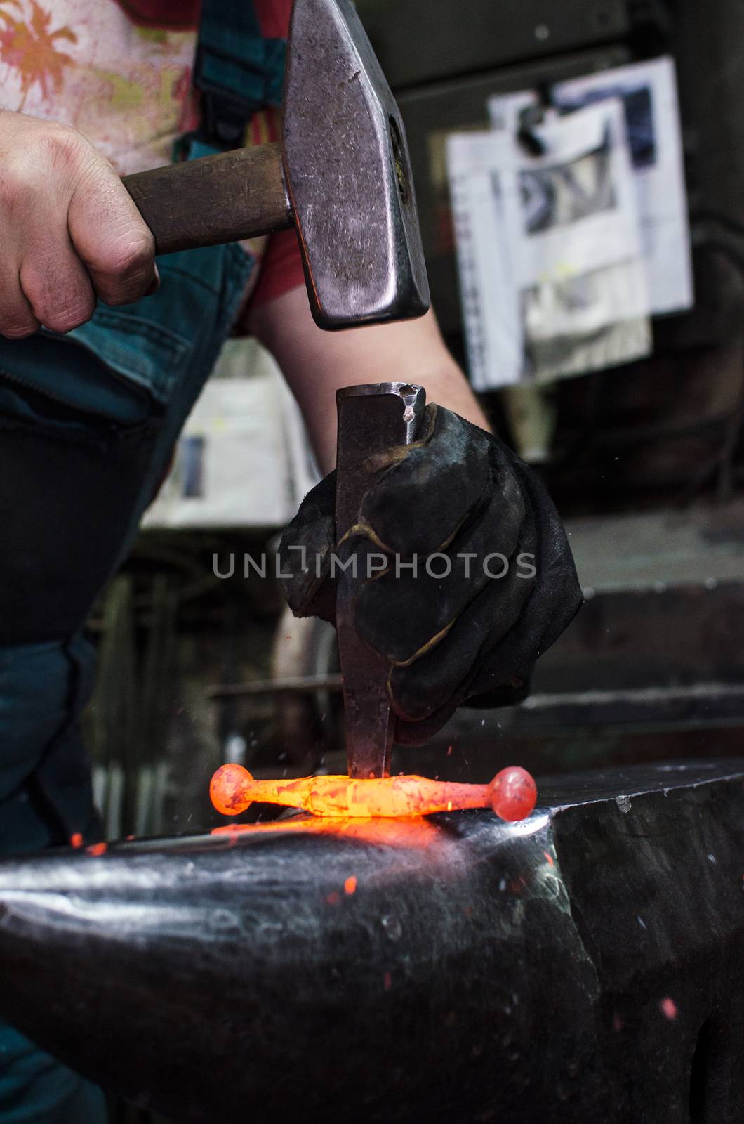 Blacksmith at work, hit with a hammer by a hot metal on the anvil.