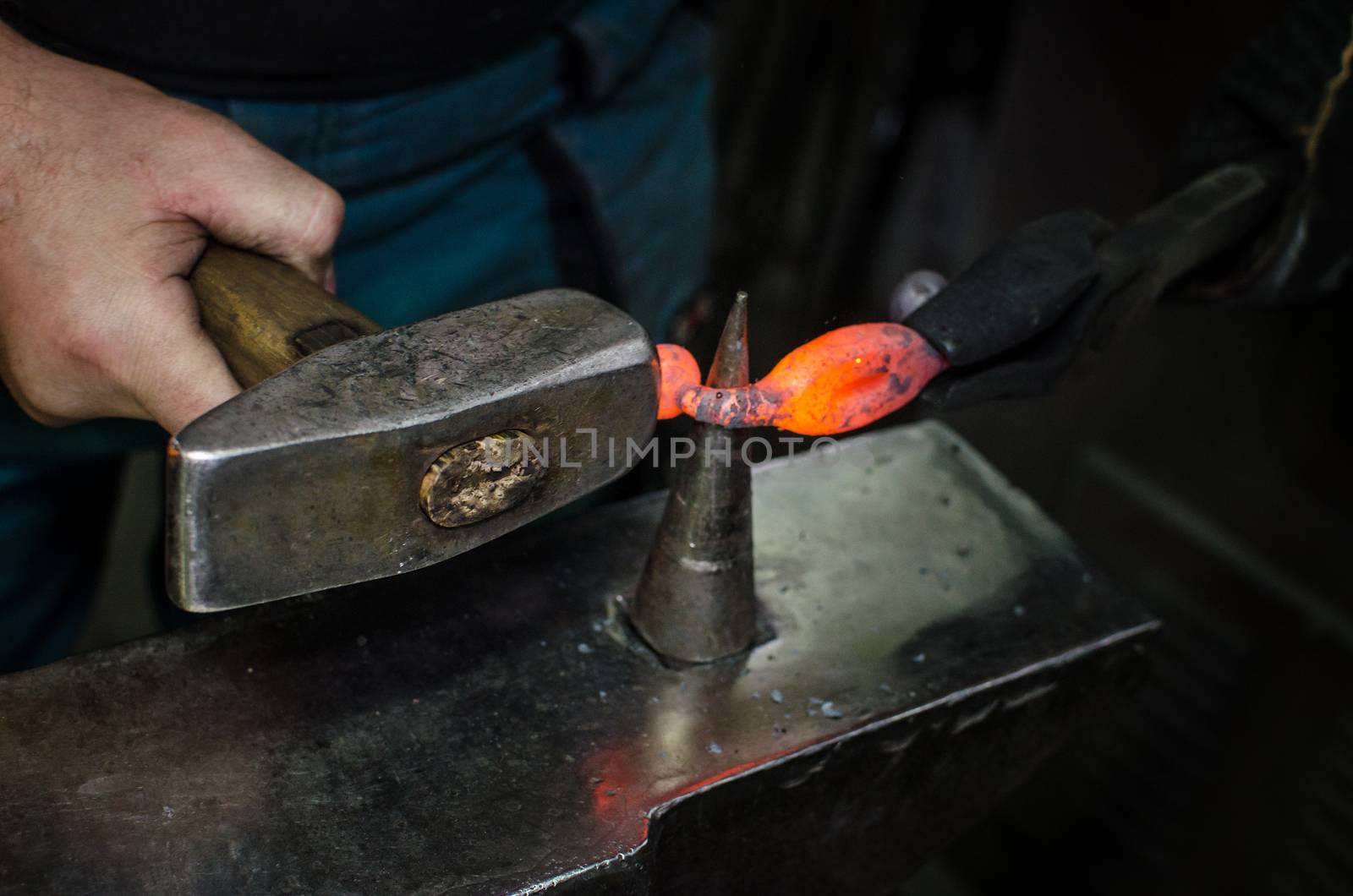 Blacksmith at work, hit with a hammer by a hot metal on the anvil.