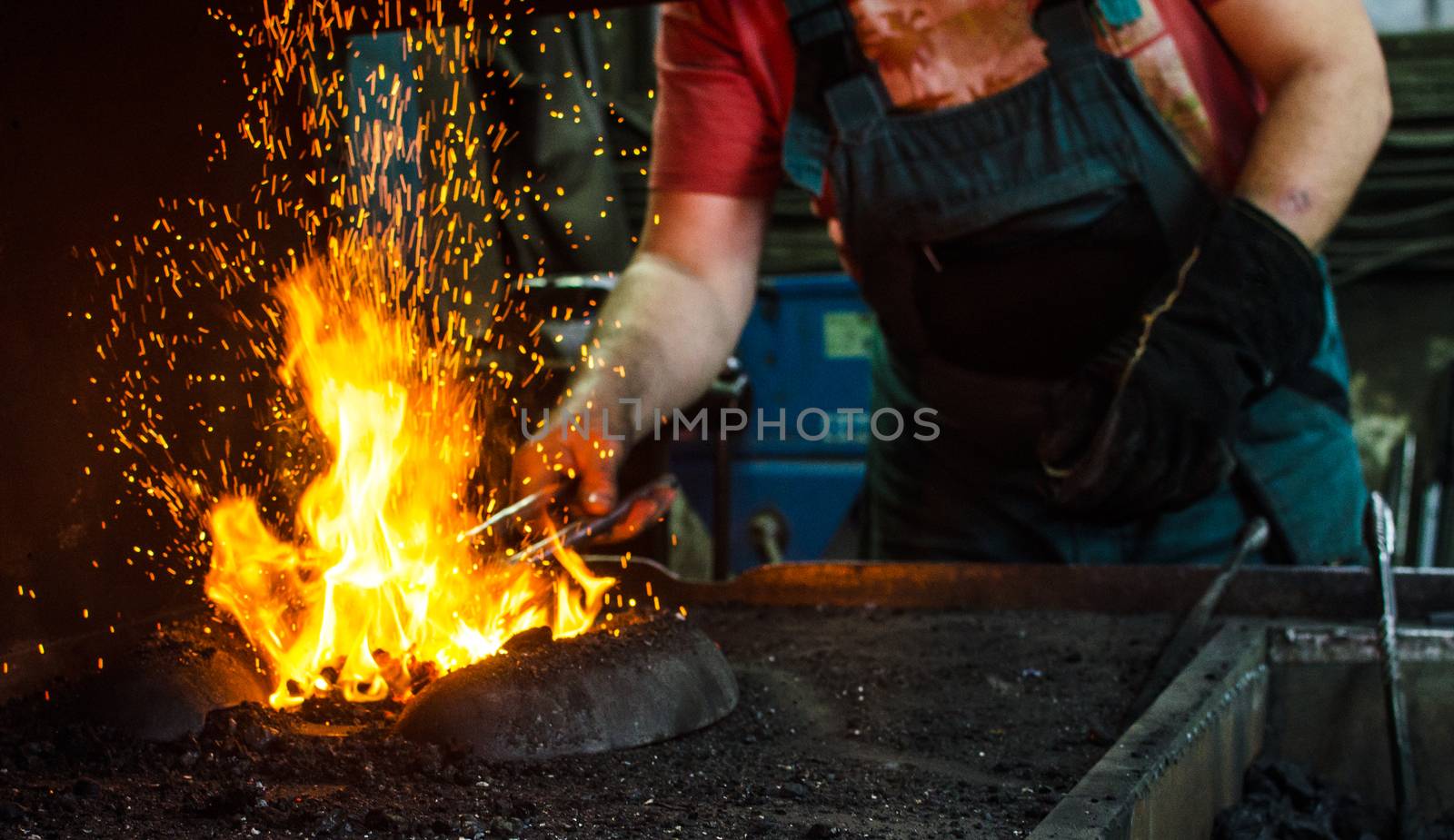 Blacksmith at work, hit with a hammer by a hot metal on the anvil.