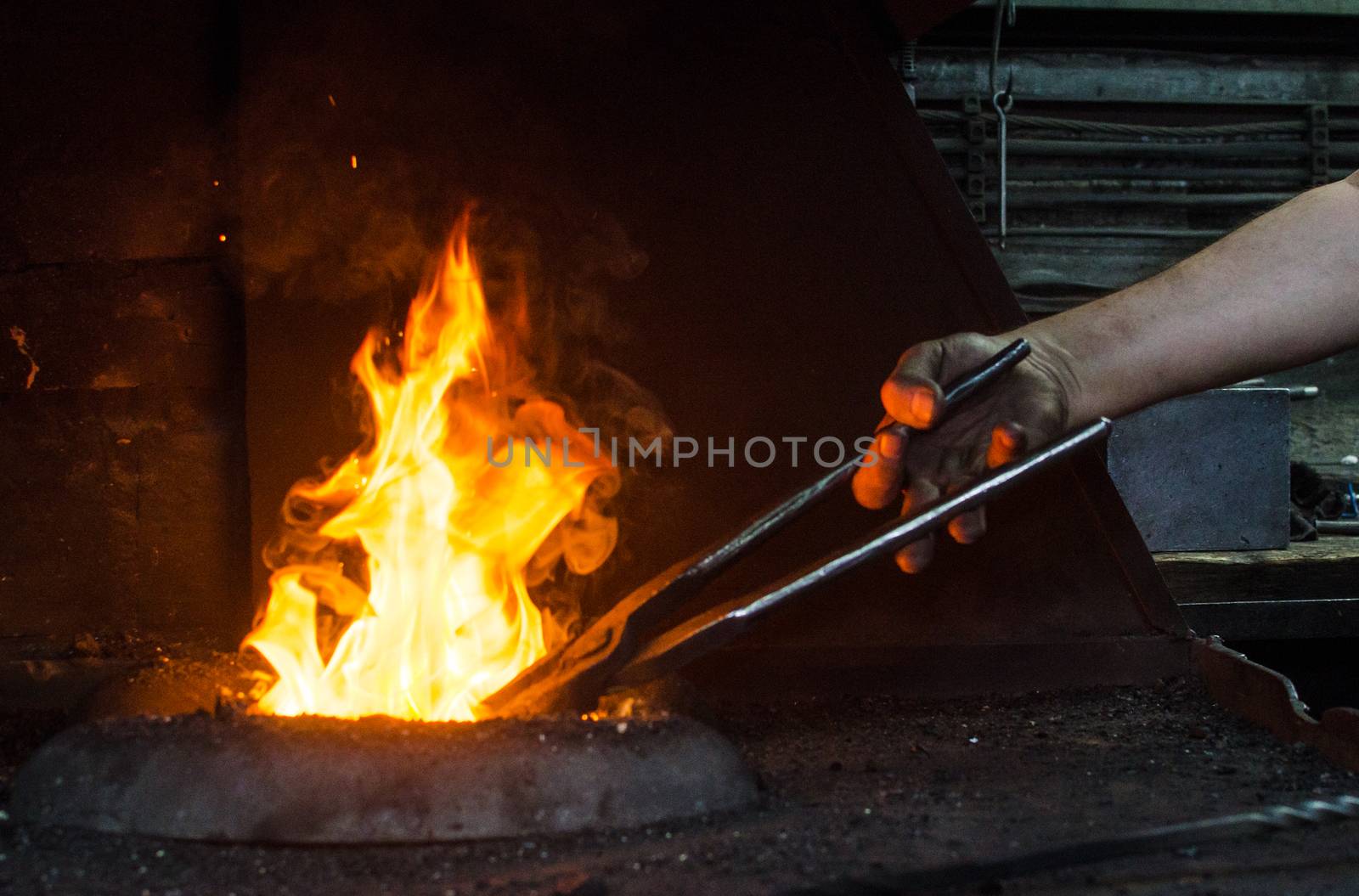 Blacksmith at work, hit with a hammer by a hot metal on the anvil.