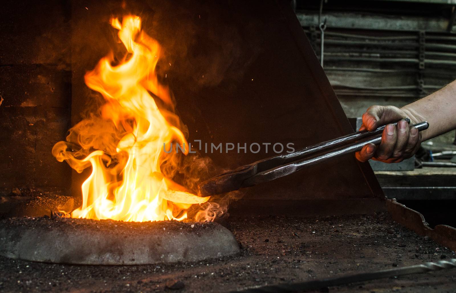 Blacksmith at work, hit with a hammer by a hot metal on the anvil.