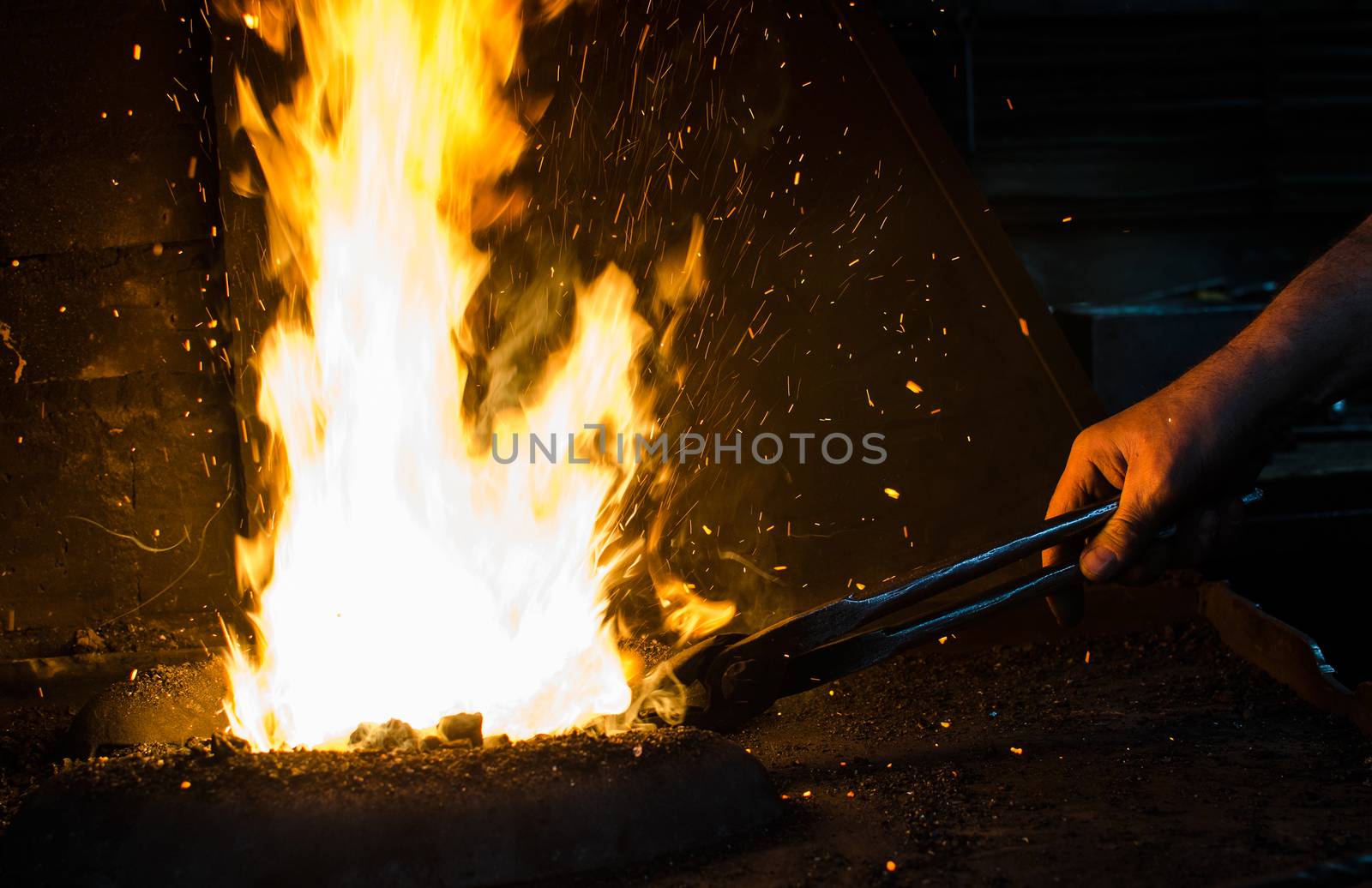Blacksmith at work, hit with a hammer by a hot metal on the anvil.