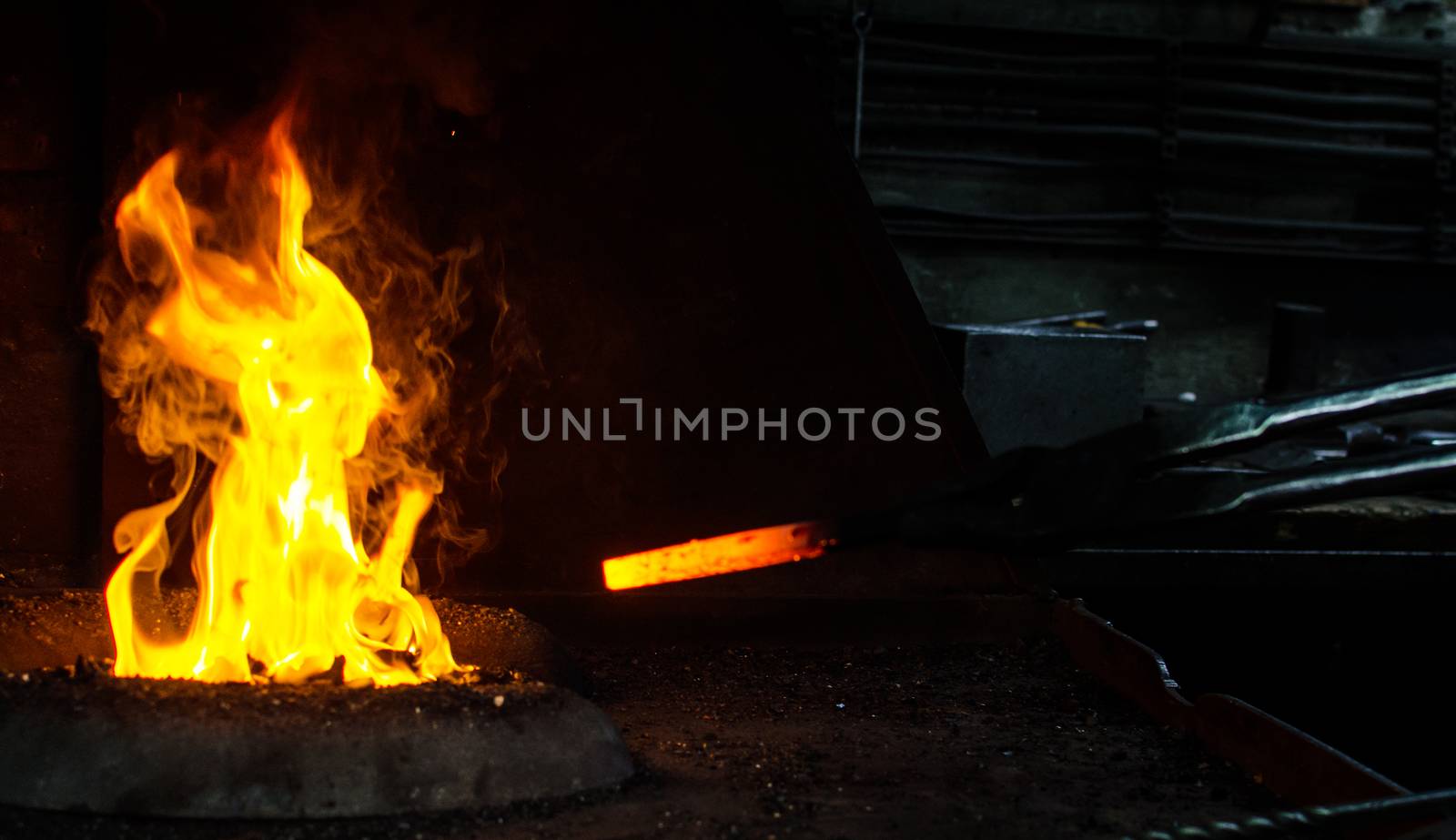 Blacksmith at work, hit with a hammer by a hot metal on the anvil.