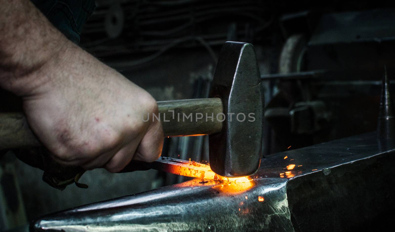 Blacksmith at work, hit with a hammer by a hot metal on the anvil.