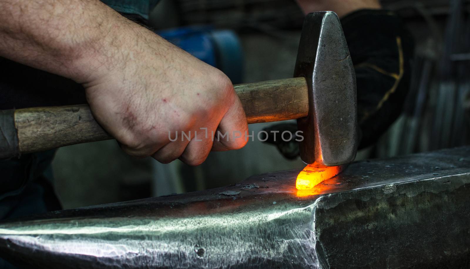 Blacksmith at work, hit with a hammer by a hot metal on the anvil.