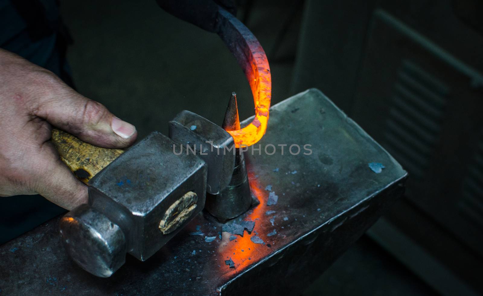 Blacksmith at work, hit with a hammer by a hot metal on the anvil.