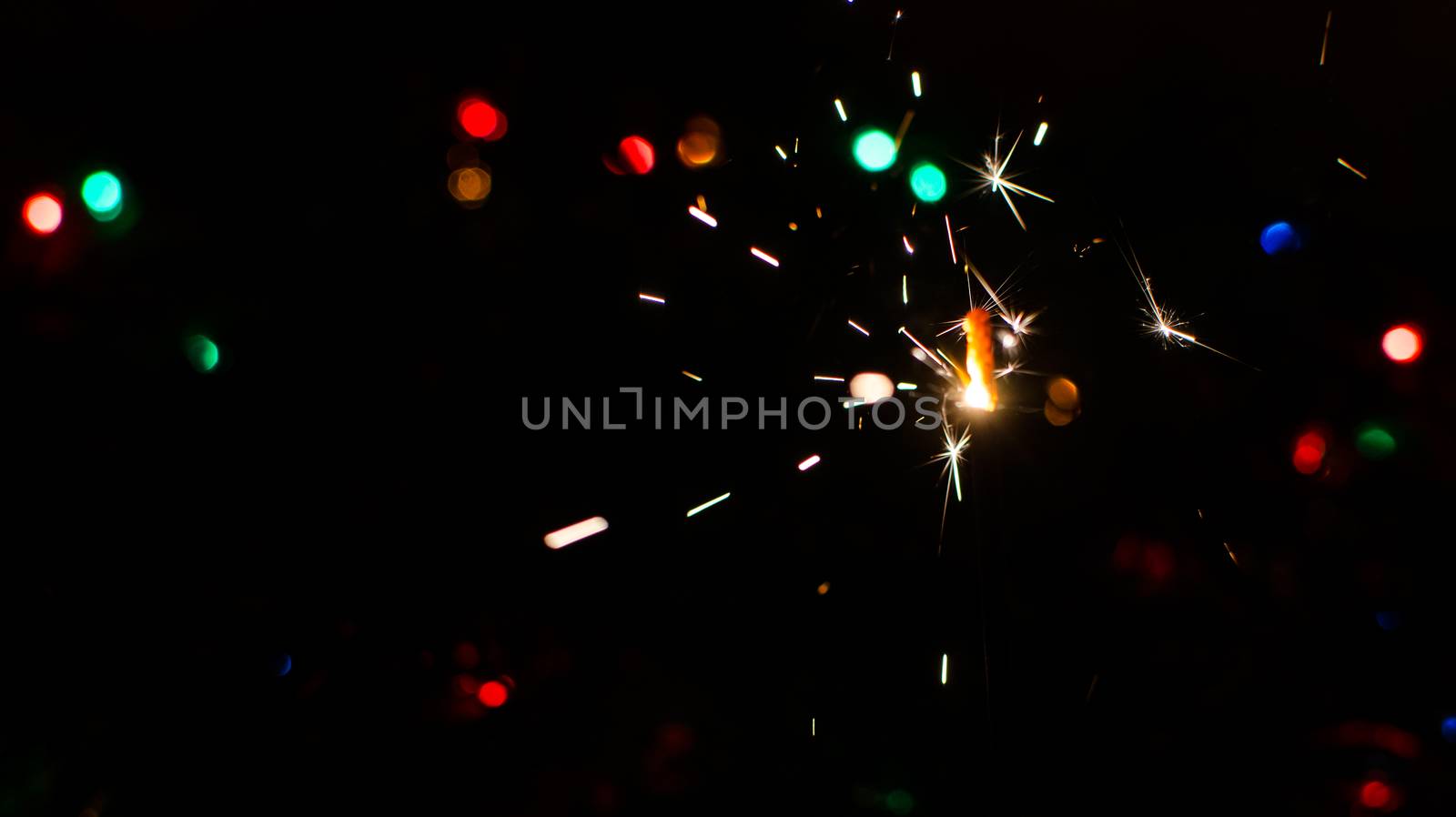 Sparkler and Christmas lights as an ideal background
