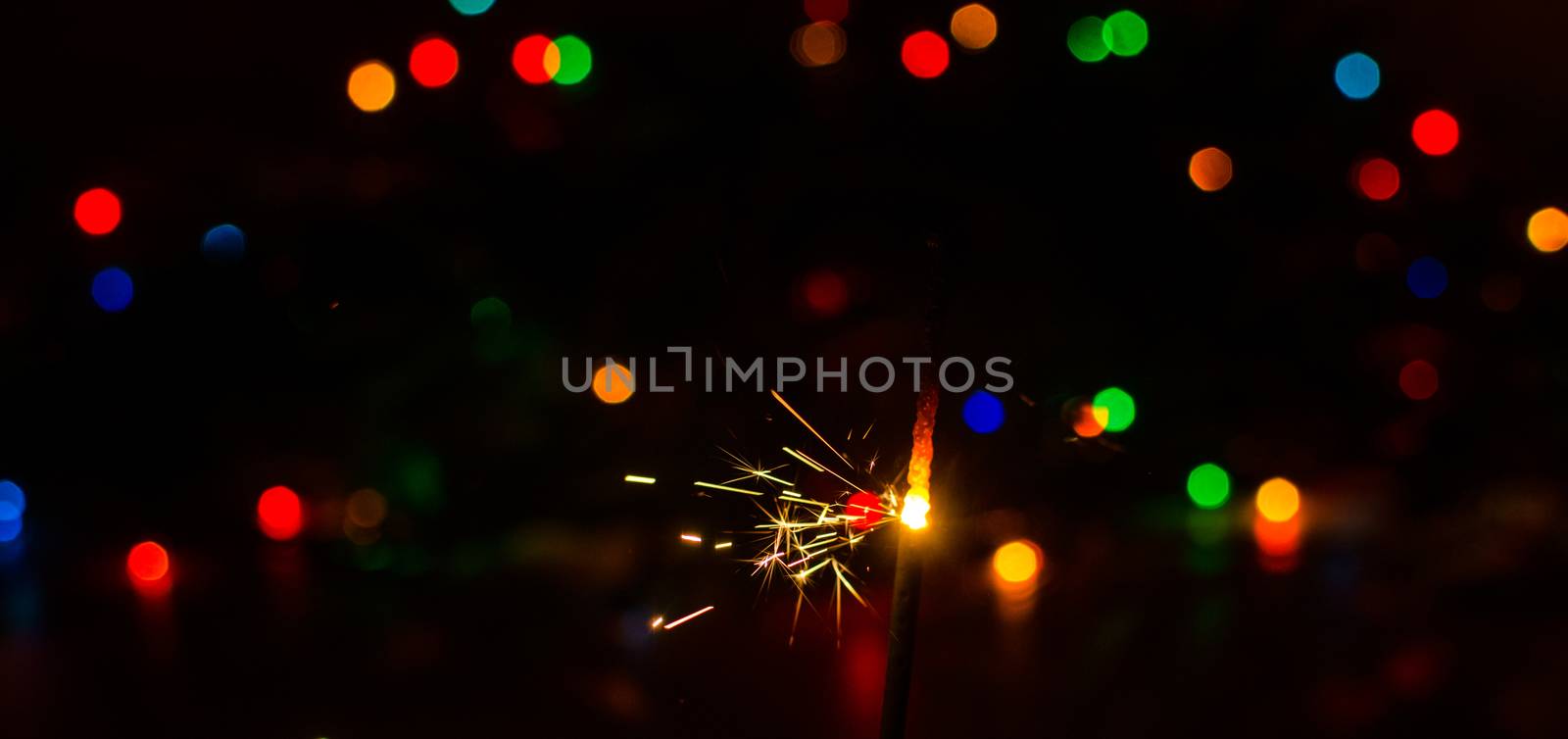 Sparkler and Christmas lights as an ideal background