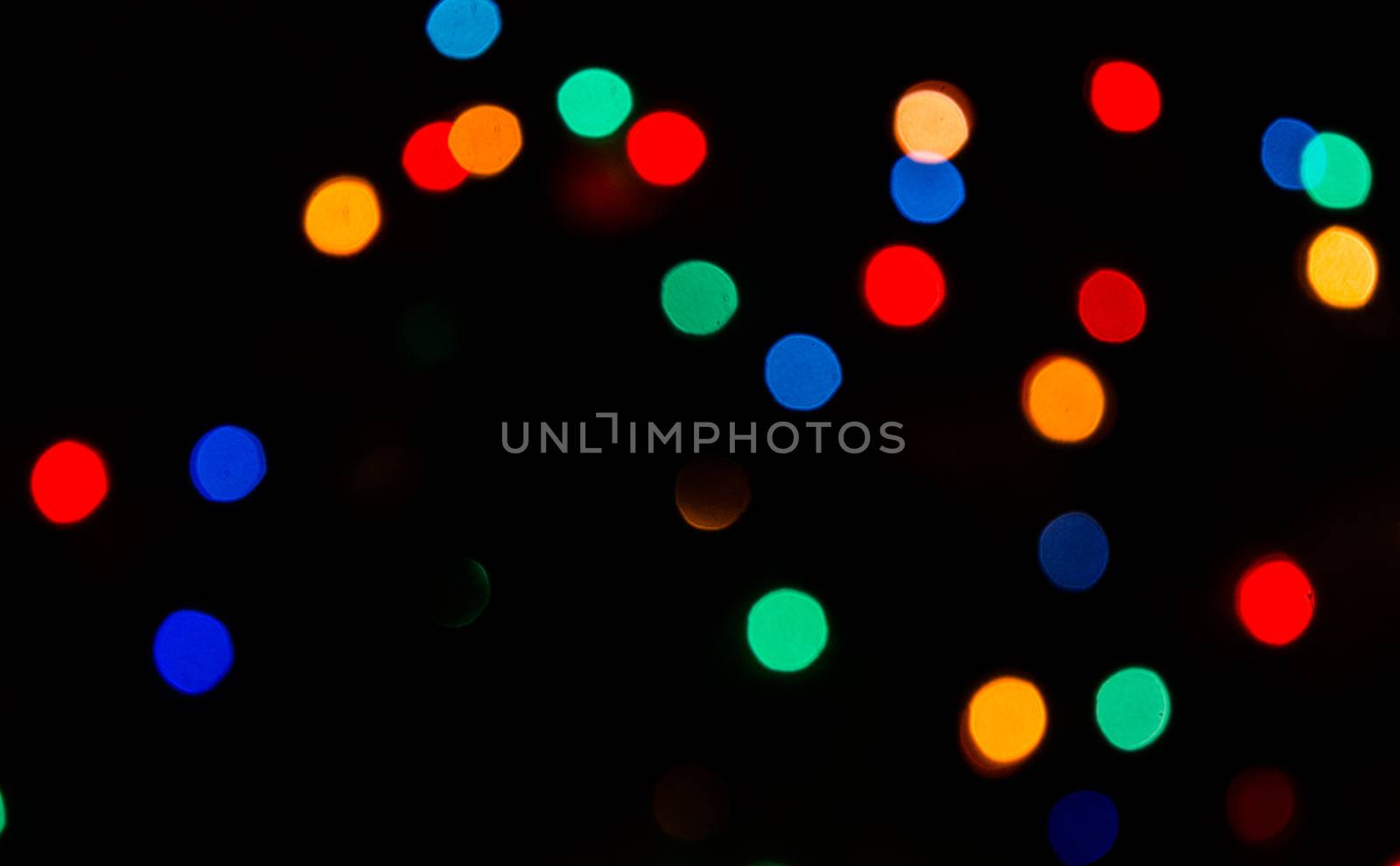 Deliberately blurred Christmas color lights in the background.