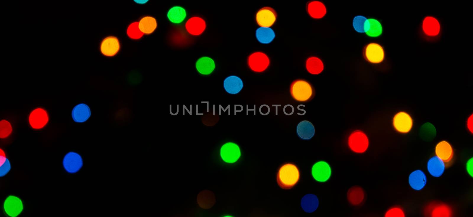 Deliberately blurred Christmas color lights in the background.