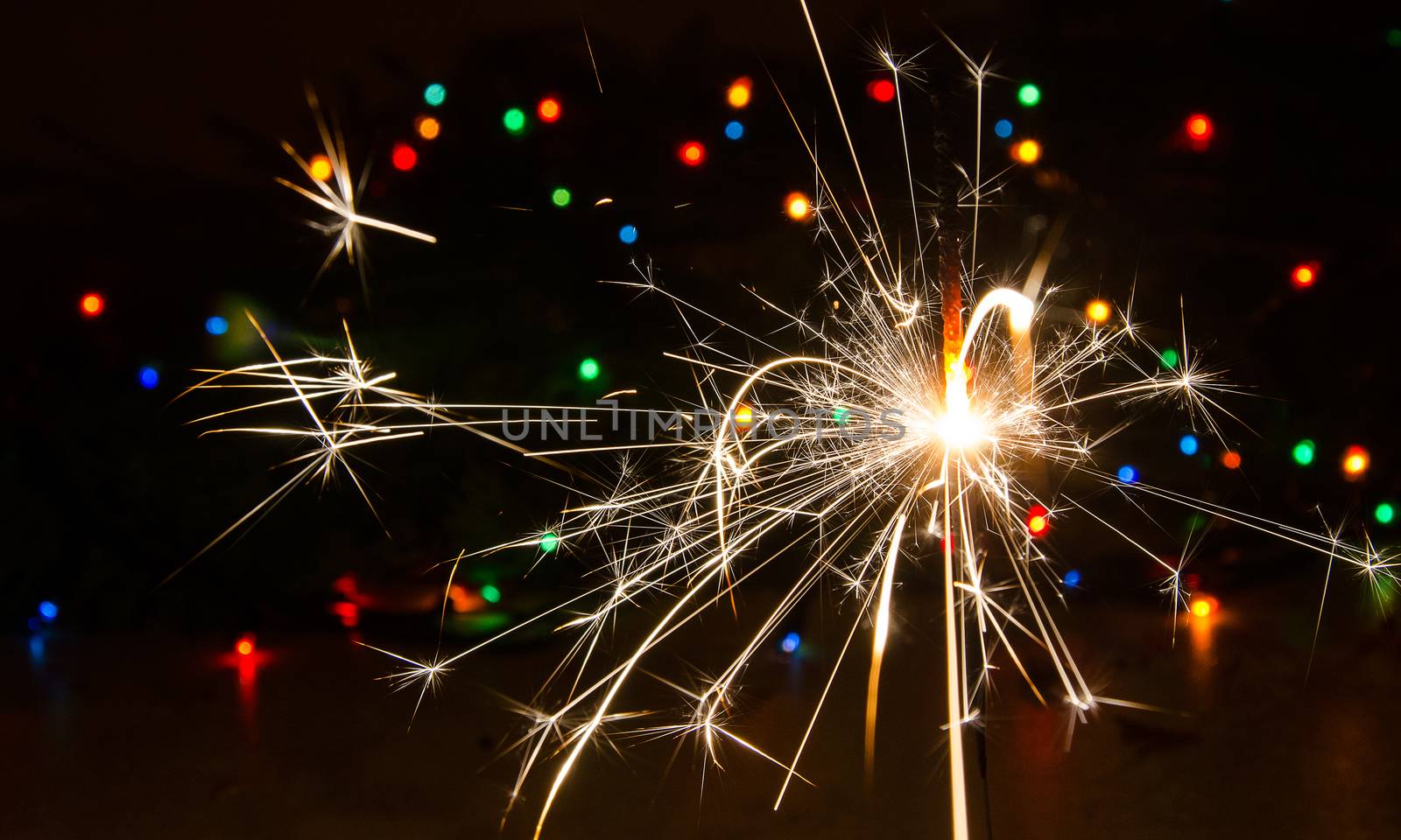 Sparkler and Christmas lights as an ideal background