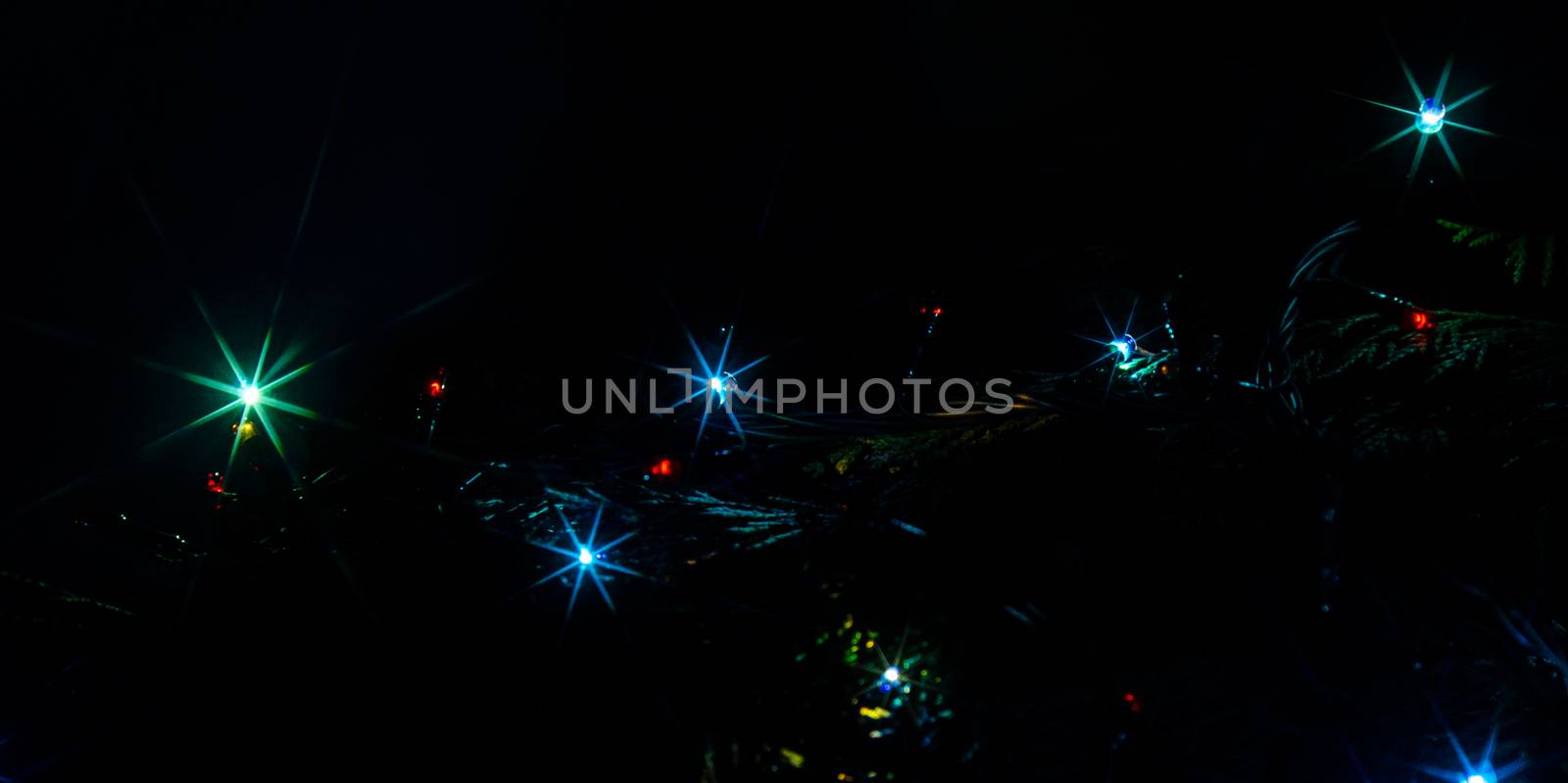 Christmas lights on a tree in different colors are classic symbol of Christmas.