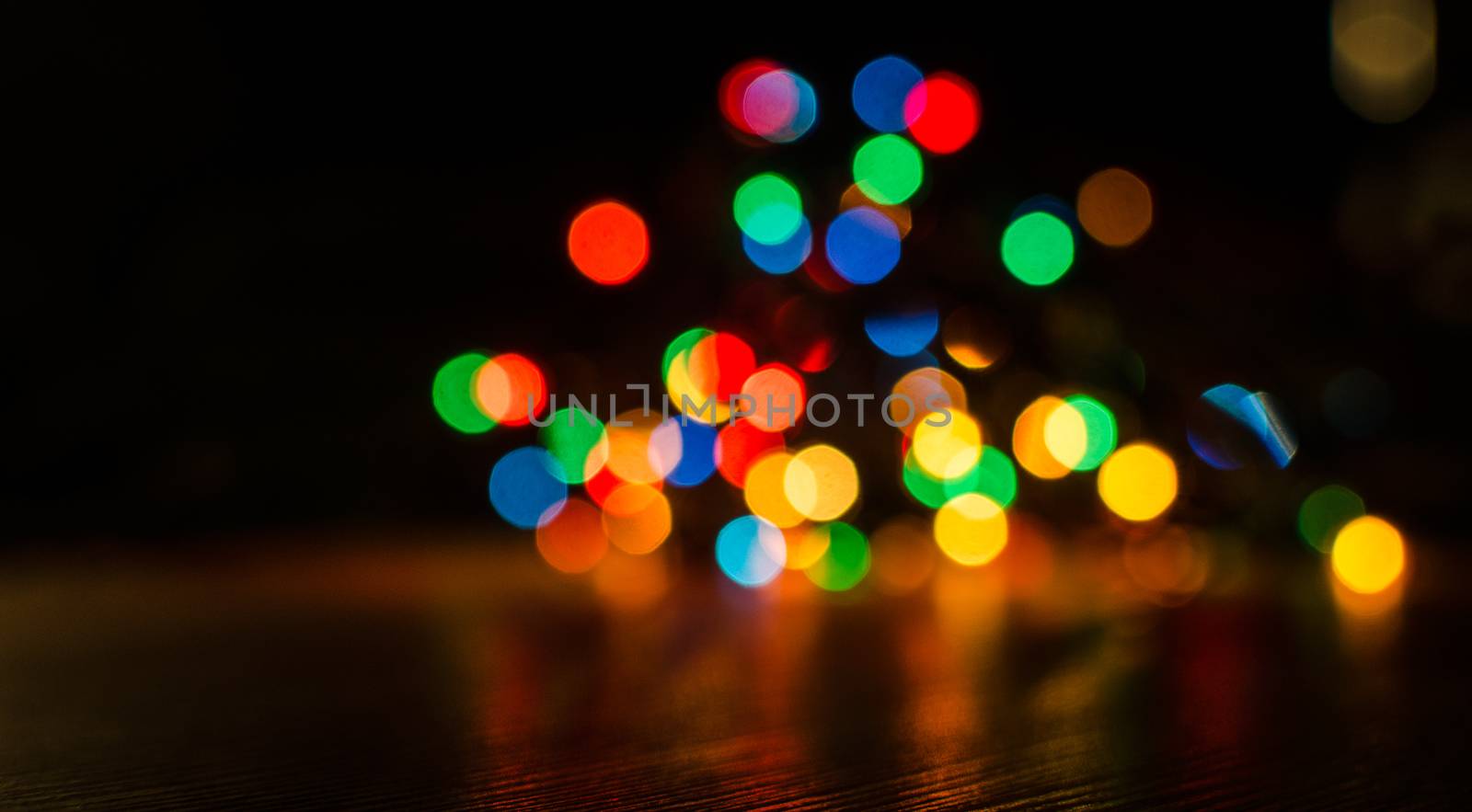 Deliberately blurred Christmas color lights in the background.