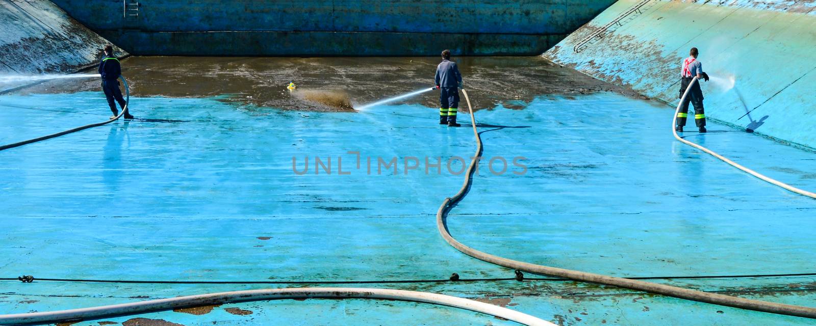 Fire hose in hand to remove the consequences of floods.