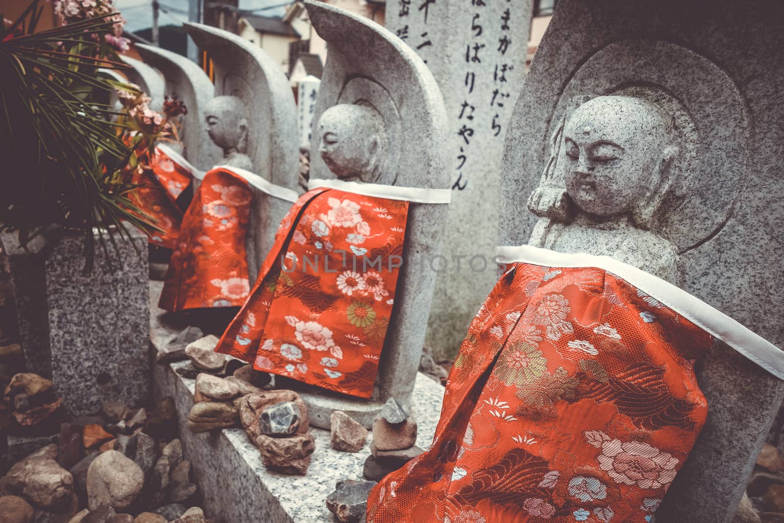 Jizo statues with red bibs in Arashiyama temple, Kyoto, Japan