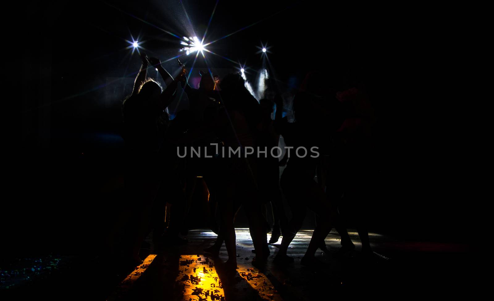 Young dancing people at the party in the shadow.