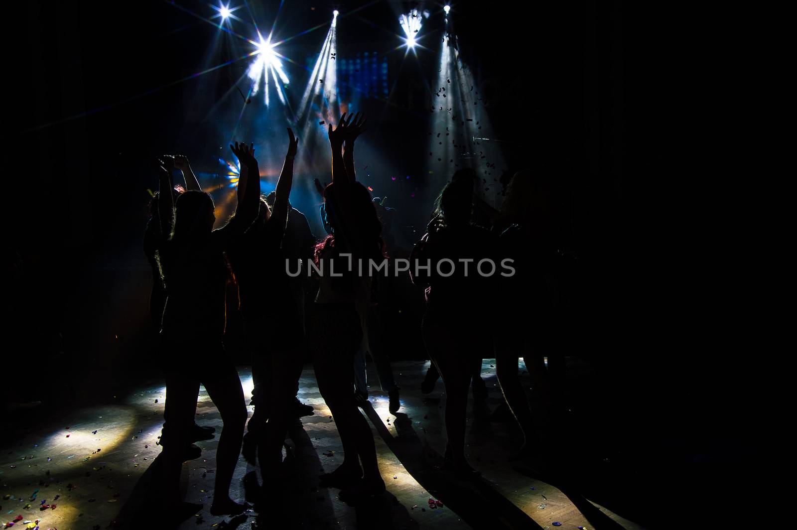 Young dancing people at the party in the shadow.