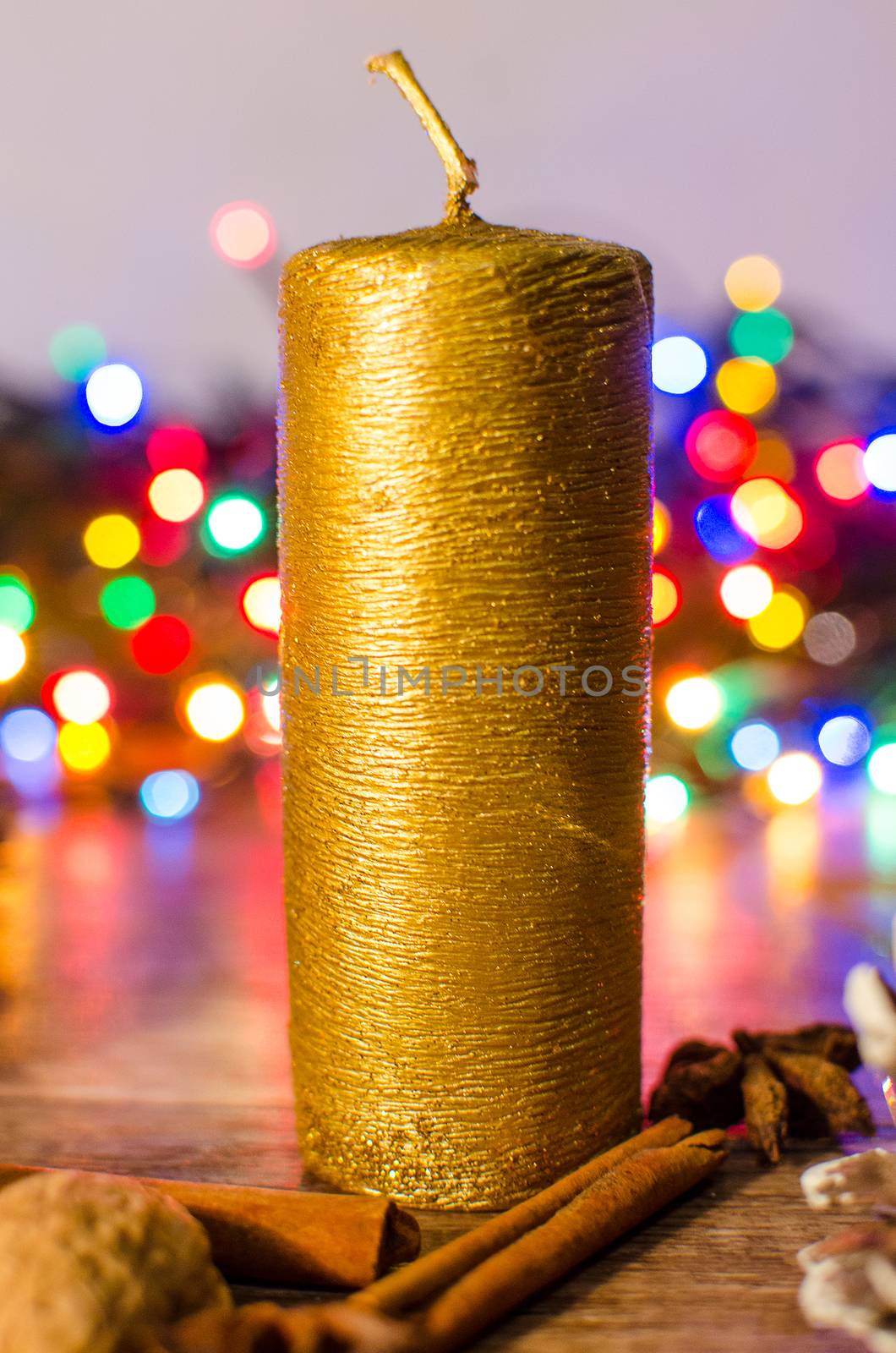 Gold candle and different colors lights are classic symbol of Christmas.