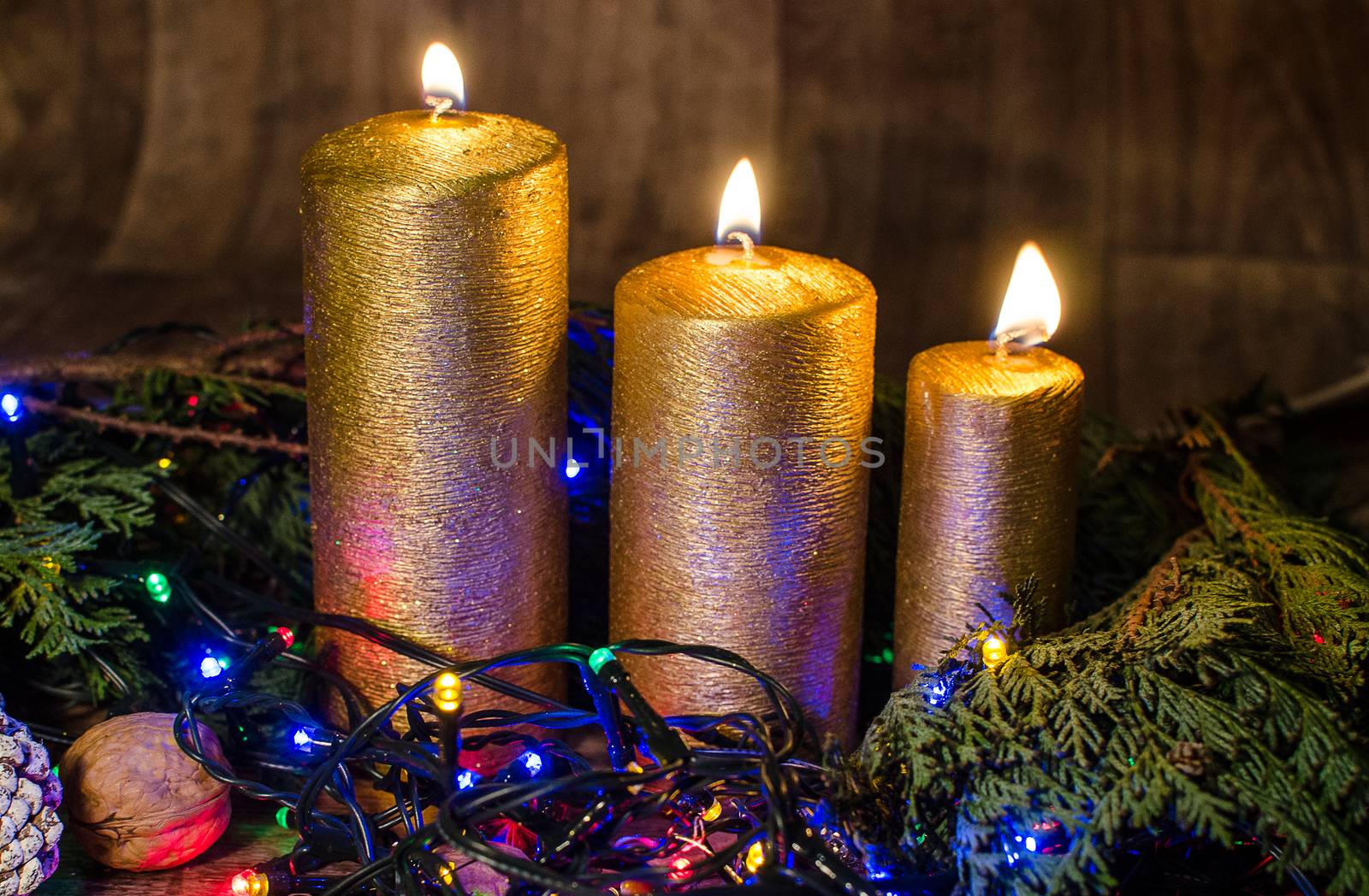 Gold candle and different colors lights are classic symbol of Christmas.