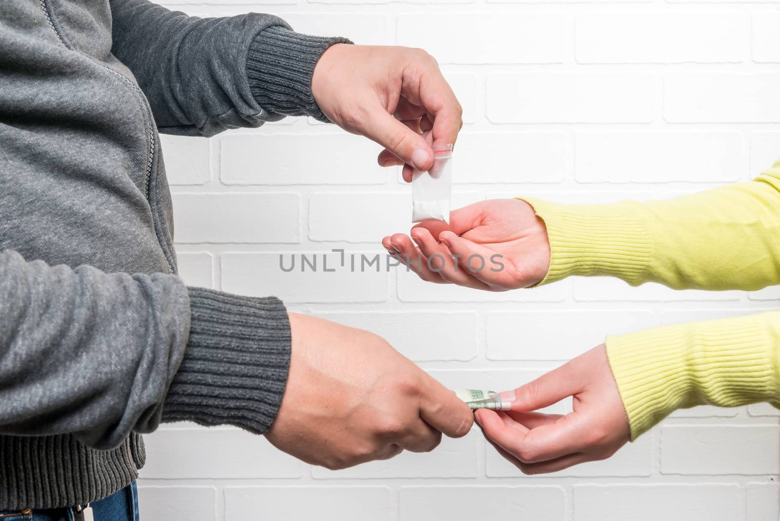 buying selling drugs hand close-up on a background of a brick white wall