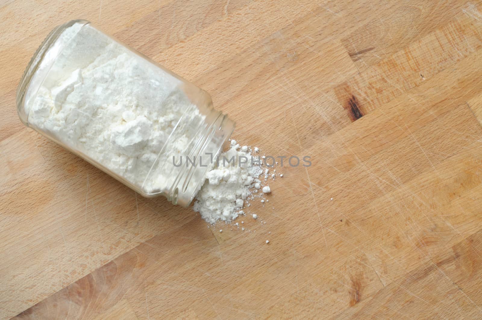 spilled flour from a glass jar, from above, large copy space