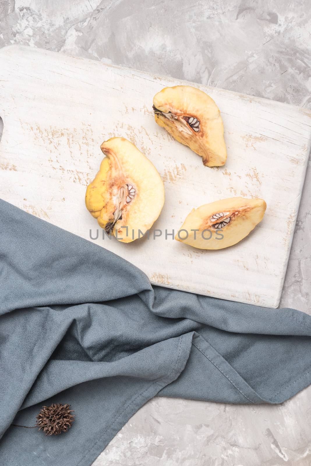 Quince fruit parts on concrete kitchen countertop.