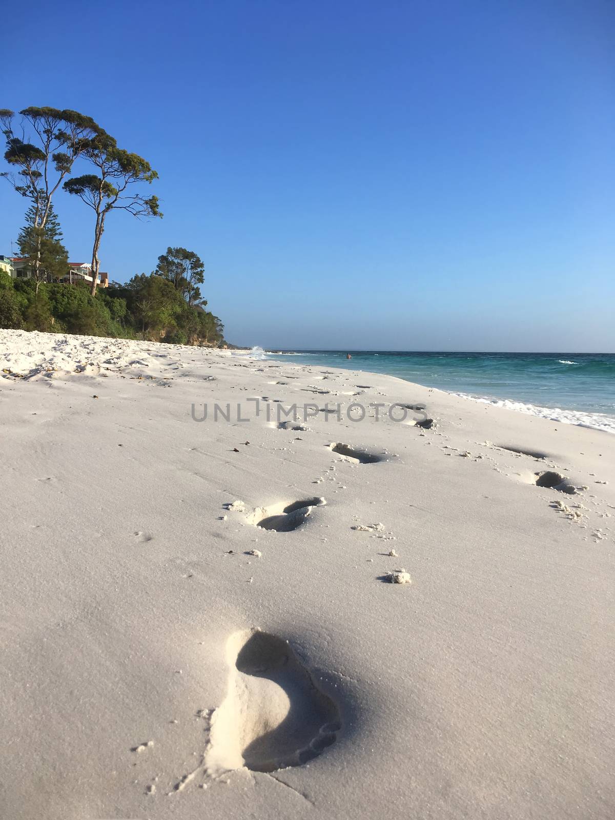 Footprints in wet sand on beach by lovleah