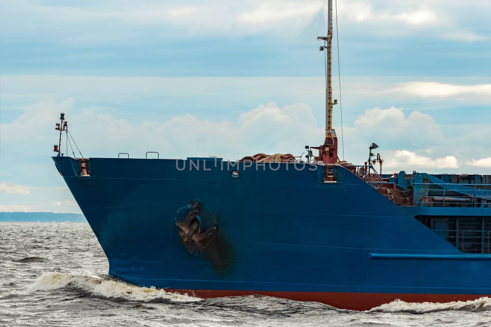 Merchandise import. Large blue cargo ship moving to Riga port