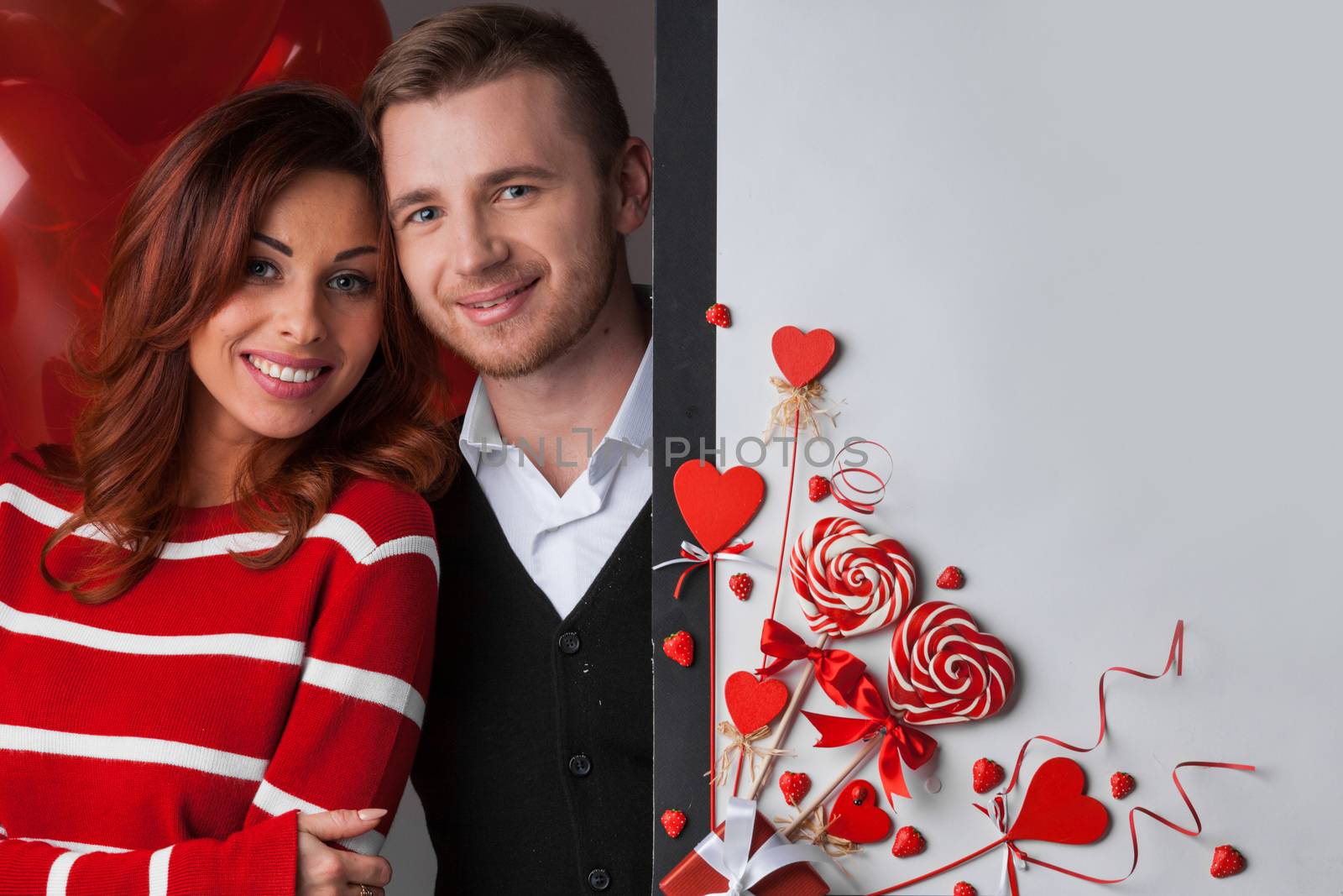 Happy couple posing with Valentine's day decoration with white copy space