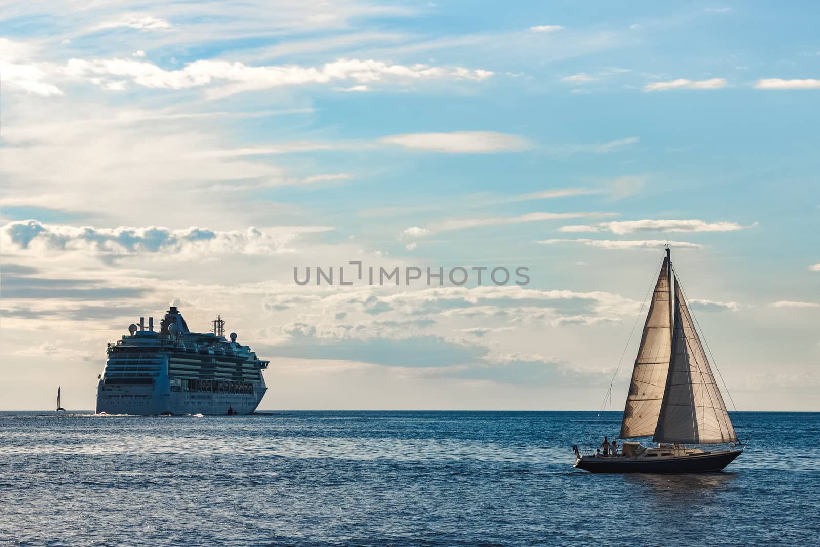 Blue sailboat traveling against the cruise liner in Riga