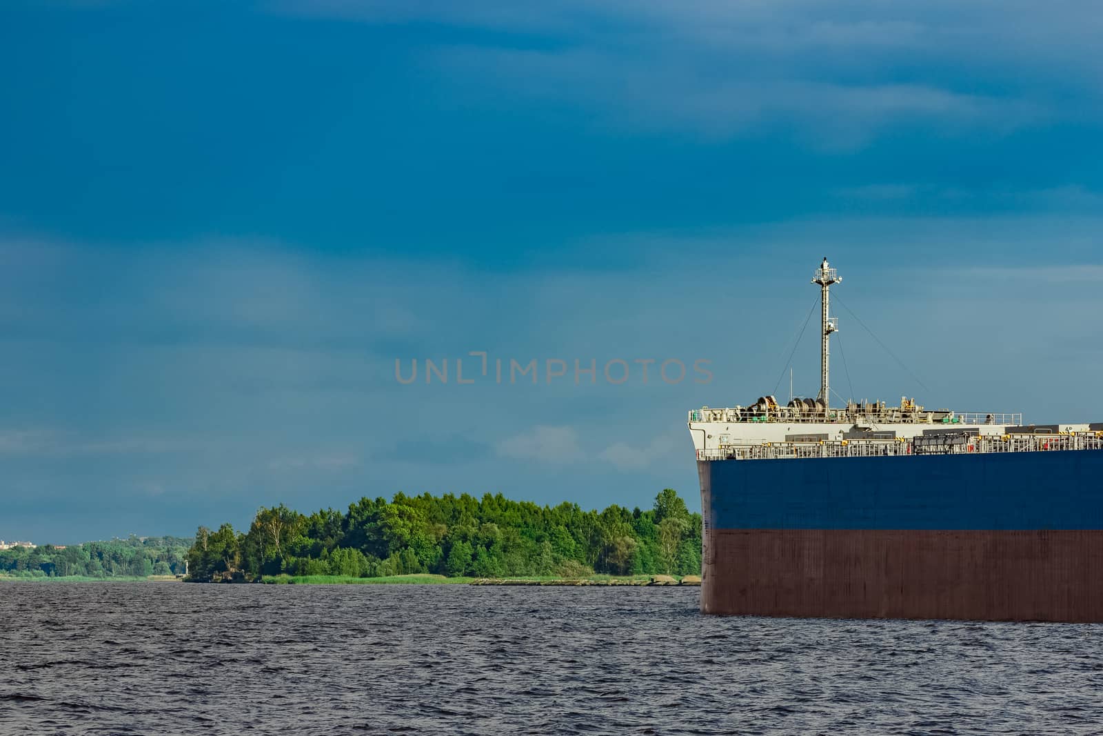 Merchandise import. Large blue cargo ship moving to Riga port