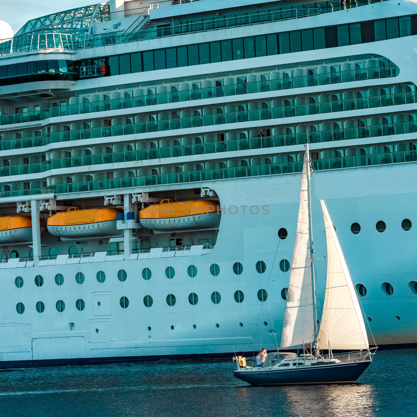 Blue sailboat against cruise liner by sengnsp