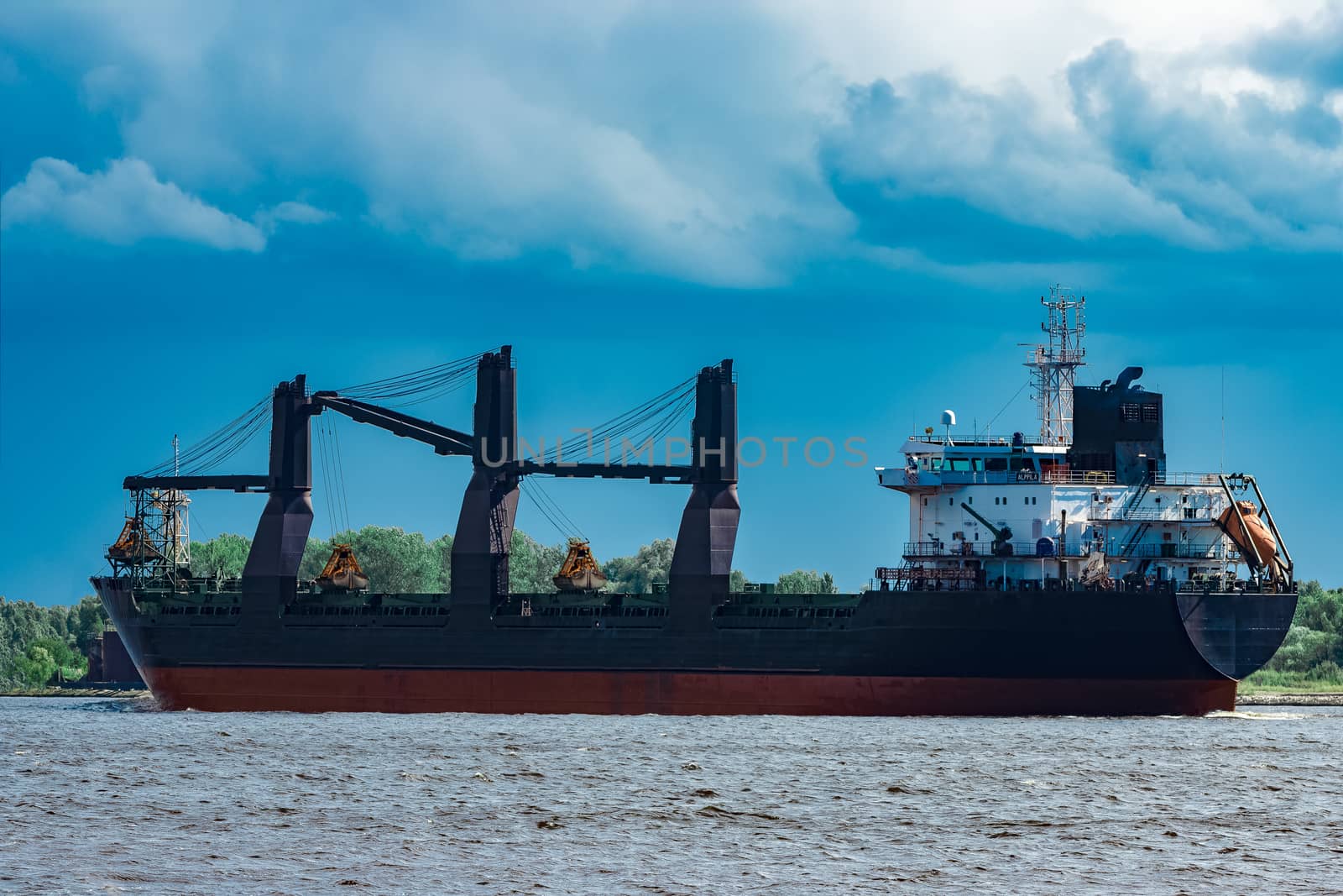 Merchandise import. Large blue cargo ship moving to Riga port