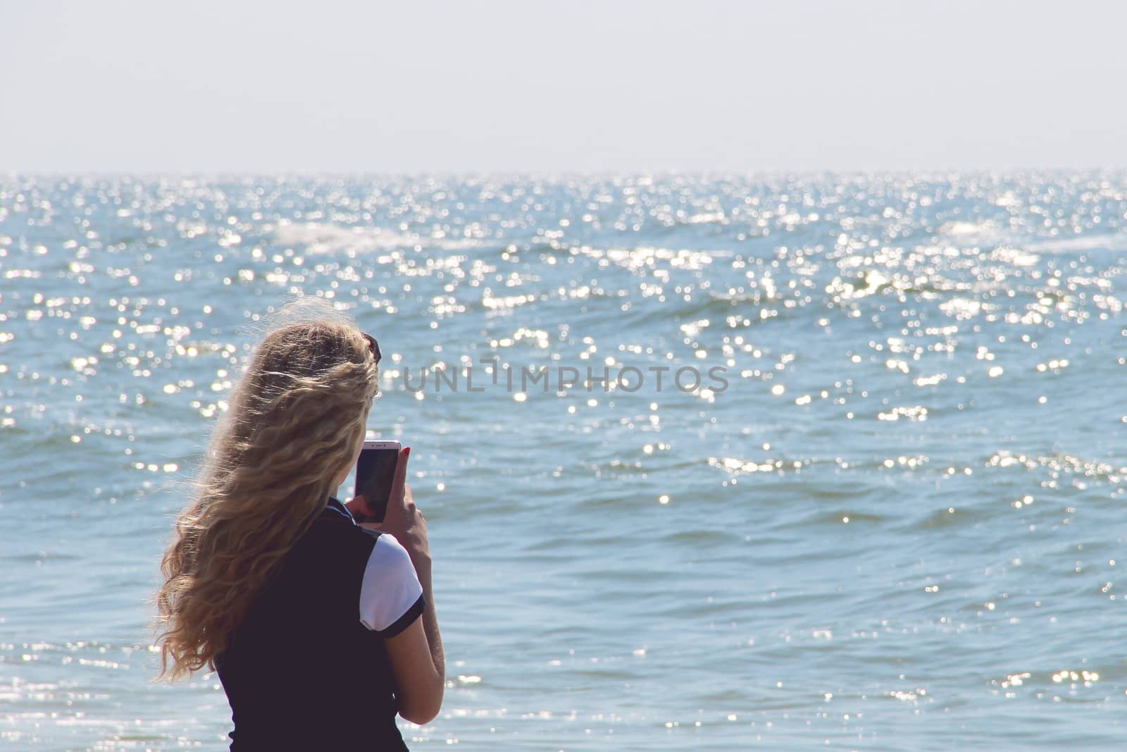 girl with mobile phone on the sea. photo