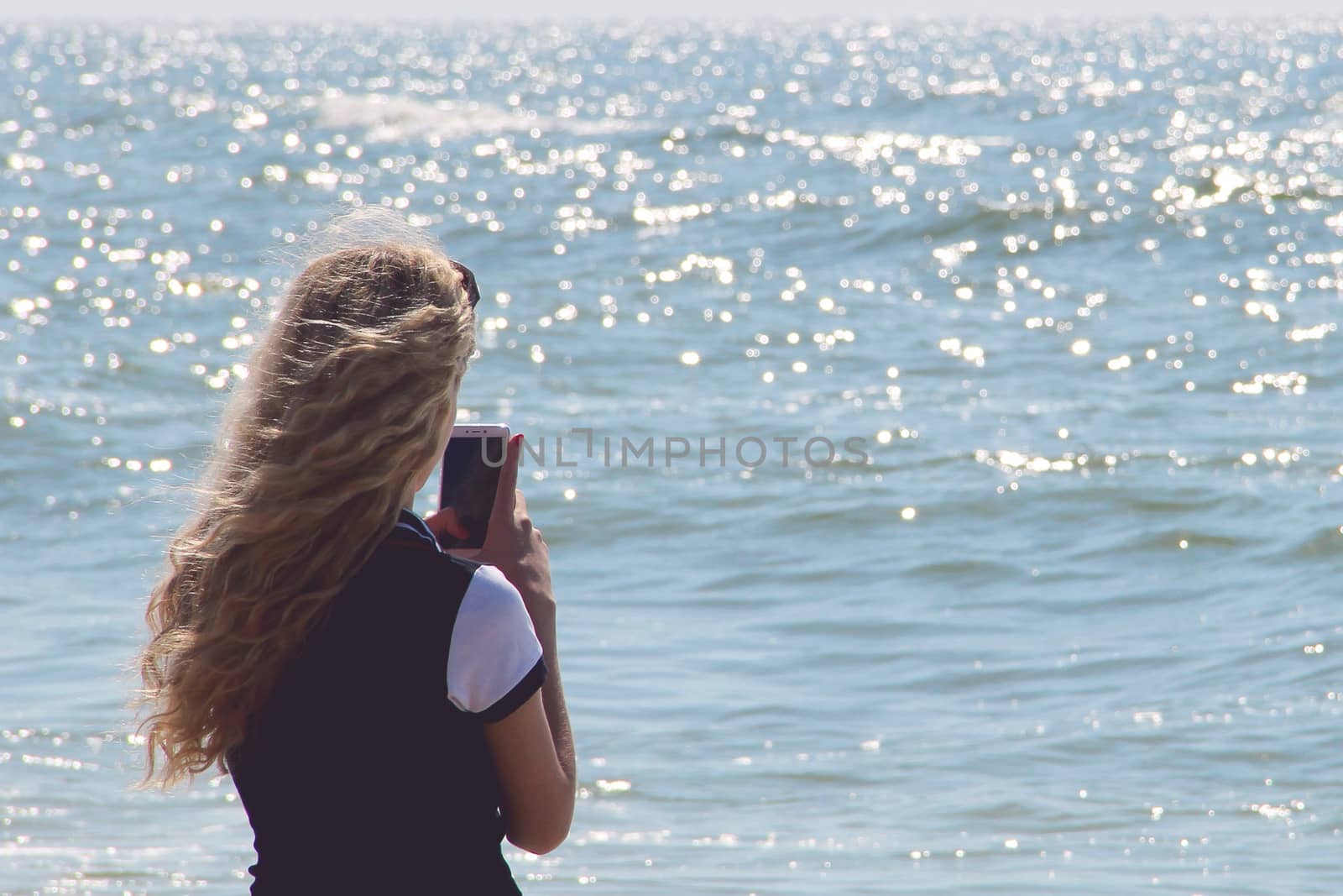 girl with mobile phone on the sea. photo