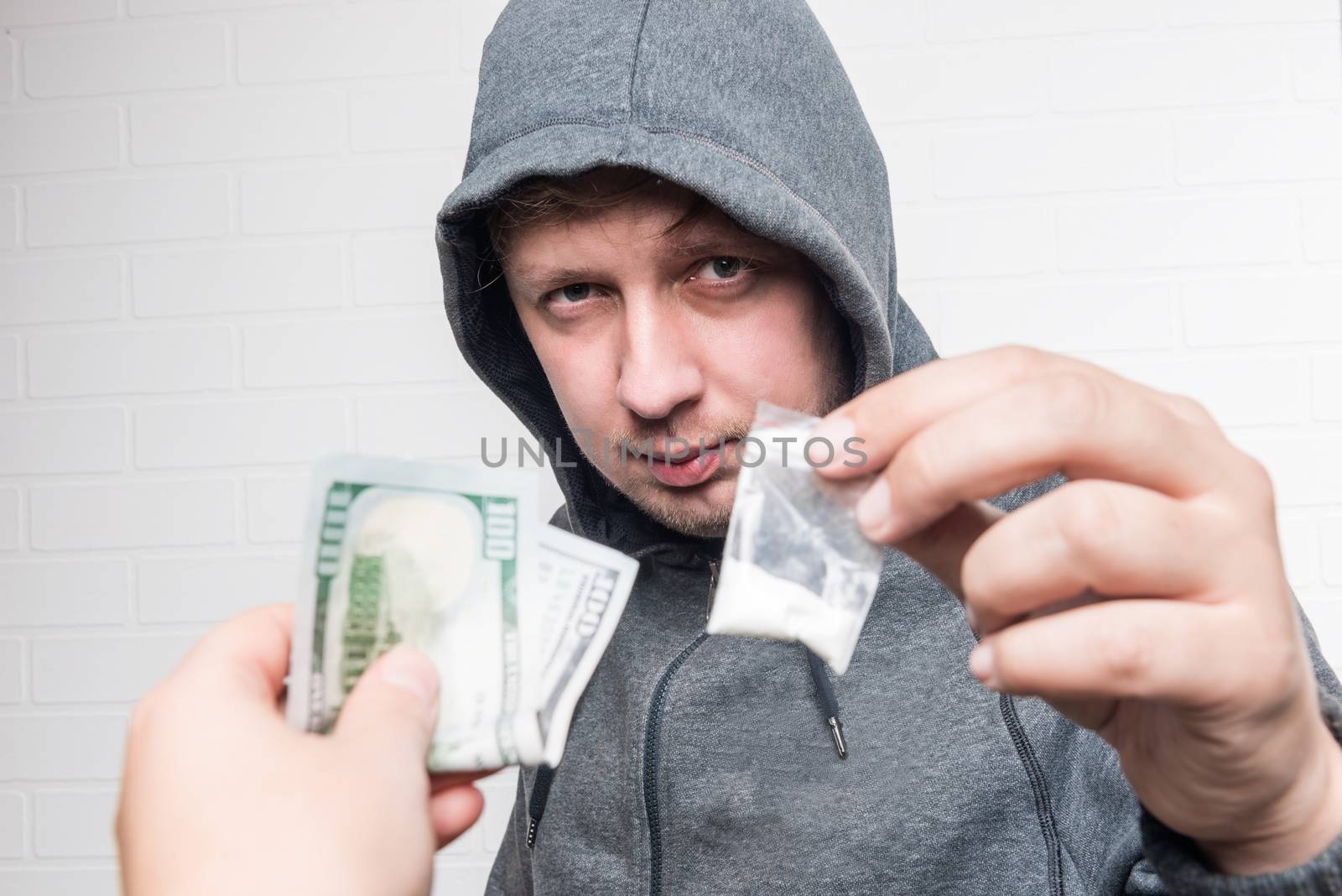 Portrait of a drug dealer with drugs and a female hand with money