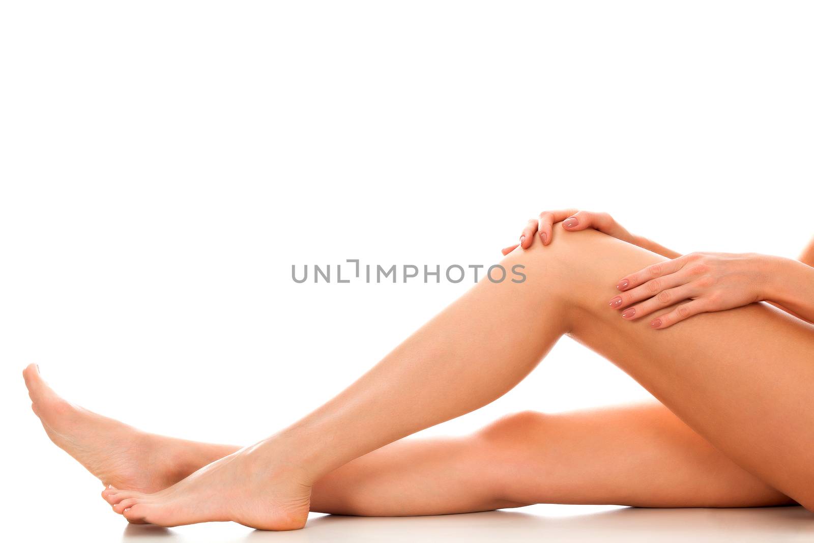 Beautiful smooth and shaved woman's legs. Isolated on white background. Skincare treatment concept