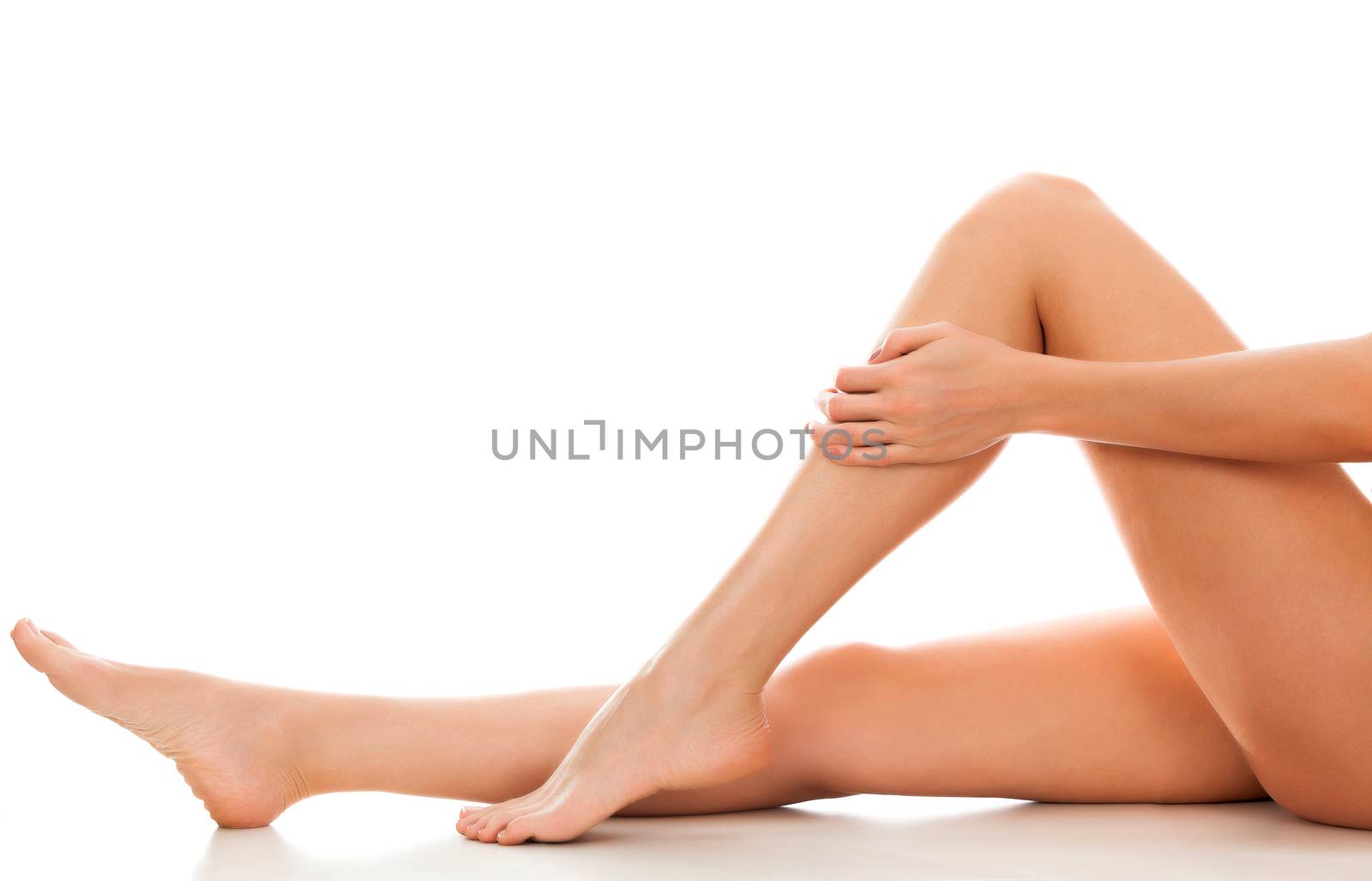 Beautiful smooth and shaved woman's legs. Isolated on white background. Skincare treatment concept