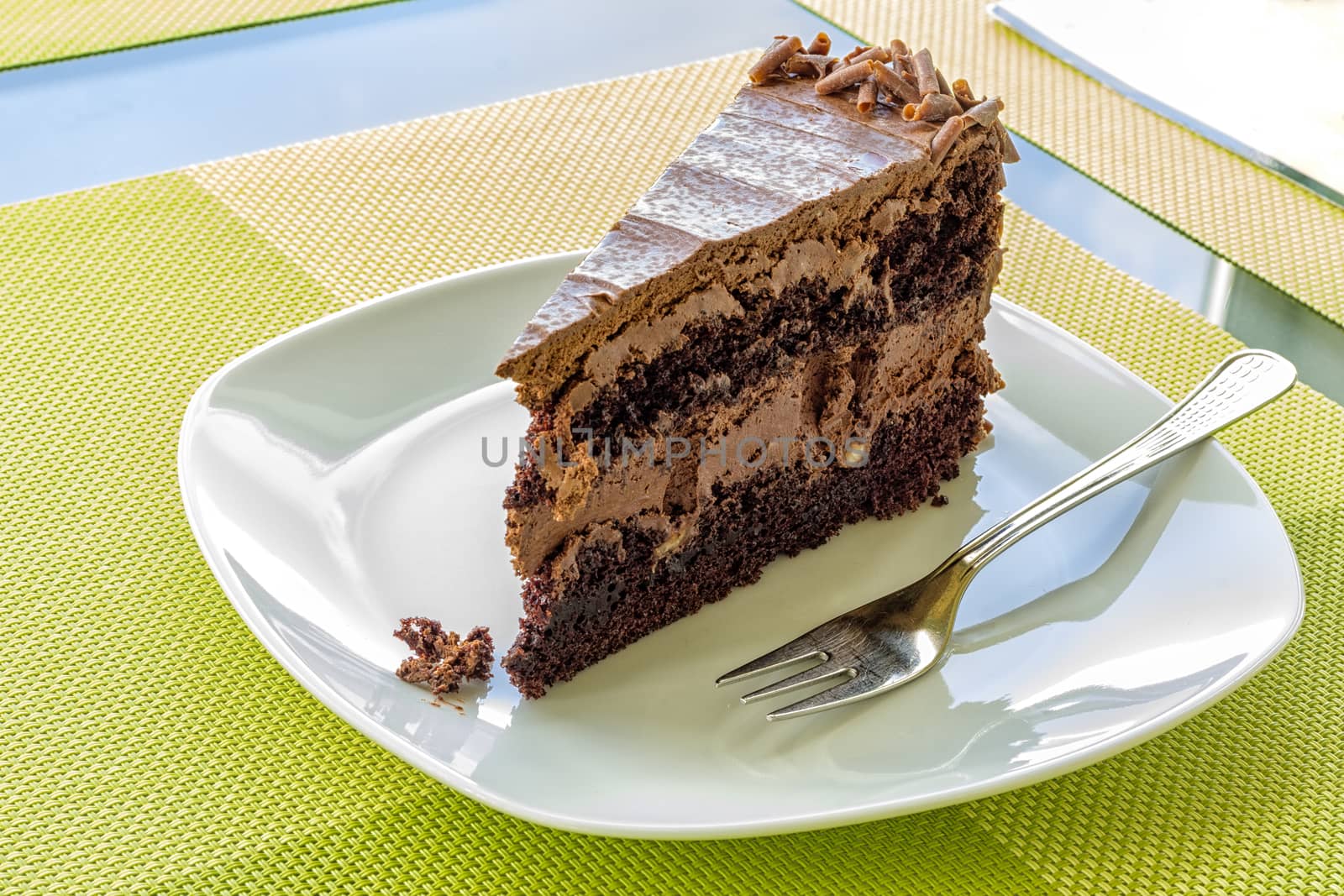 a delicate piece of chocolate cake, torte on a white plate with a fork