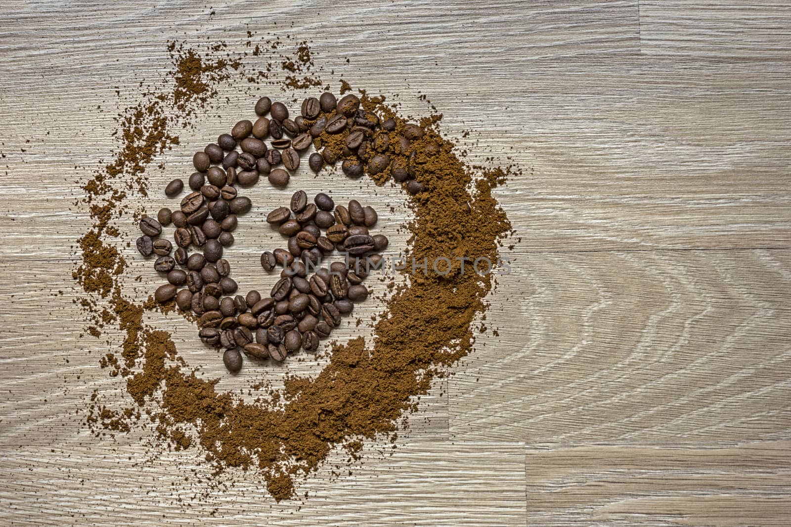 Coffee beans and ground coffee on a wooden table like a spiral.  Vintage style concept