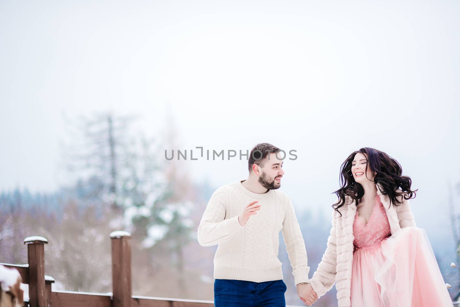 young couple on a walk in the snowy mountains by Andreua