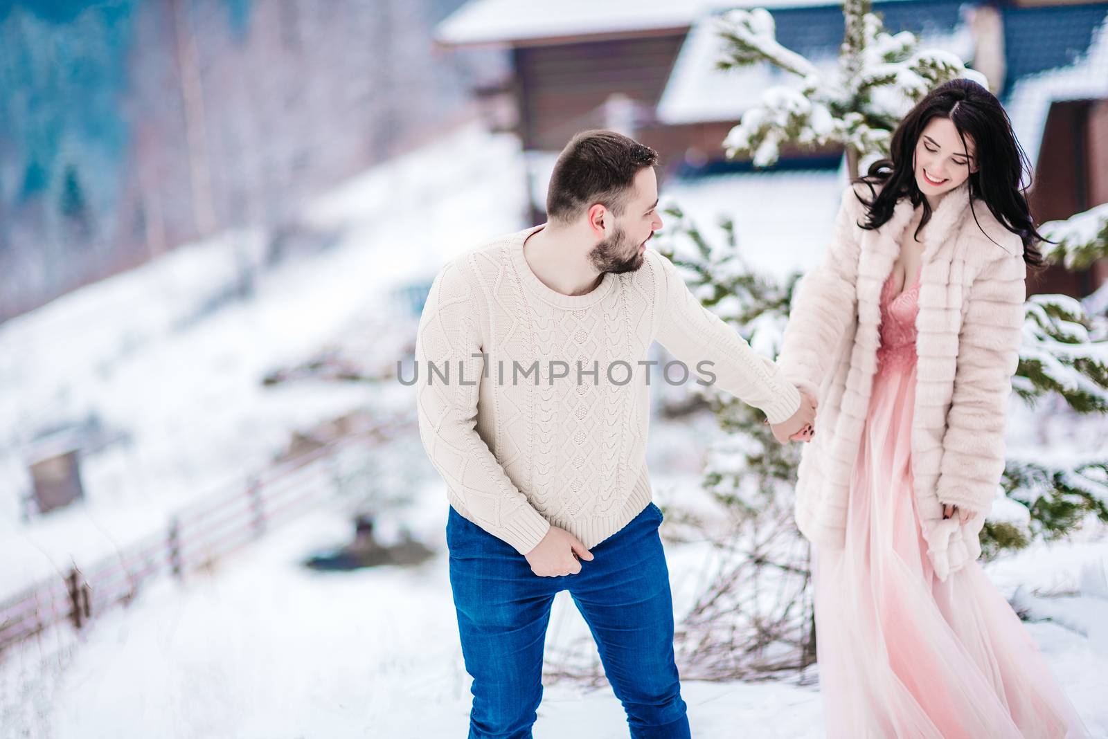 a bride in a fur coat with a fiance among the Carpathian mountains